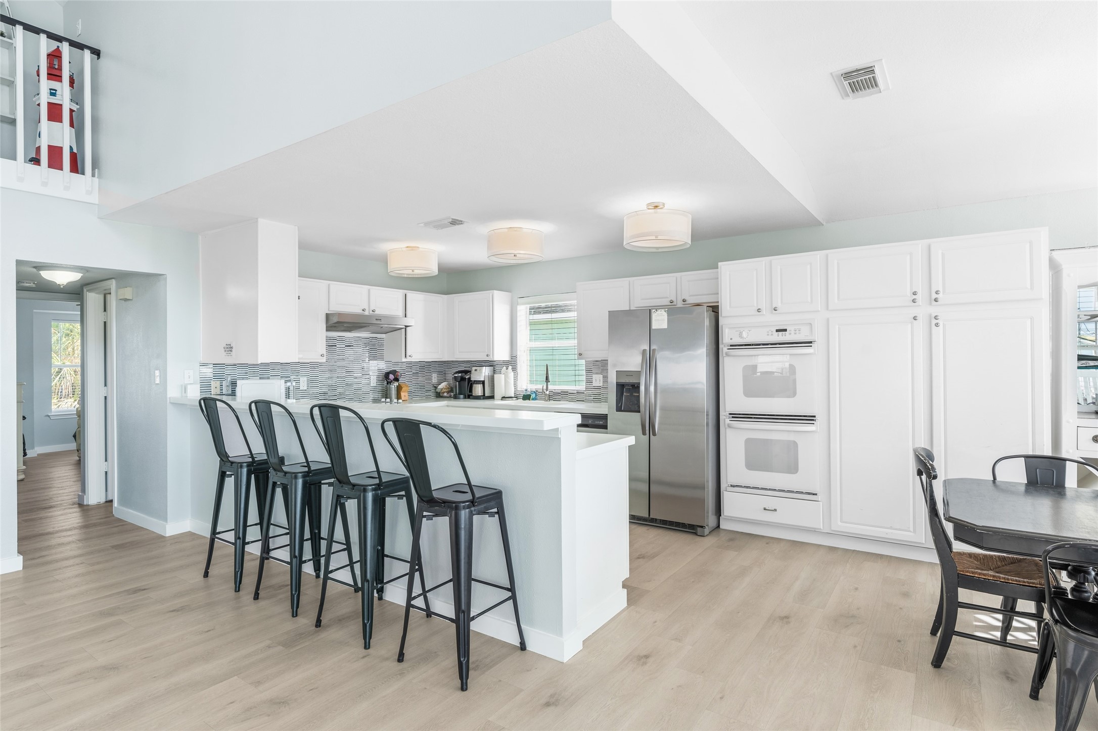Bright kitchen featuring ample cabinet space and a large breakfast bar with seating, perfect for casual meals and entertaining.
