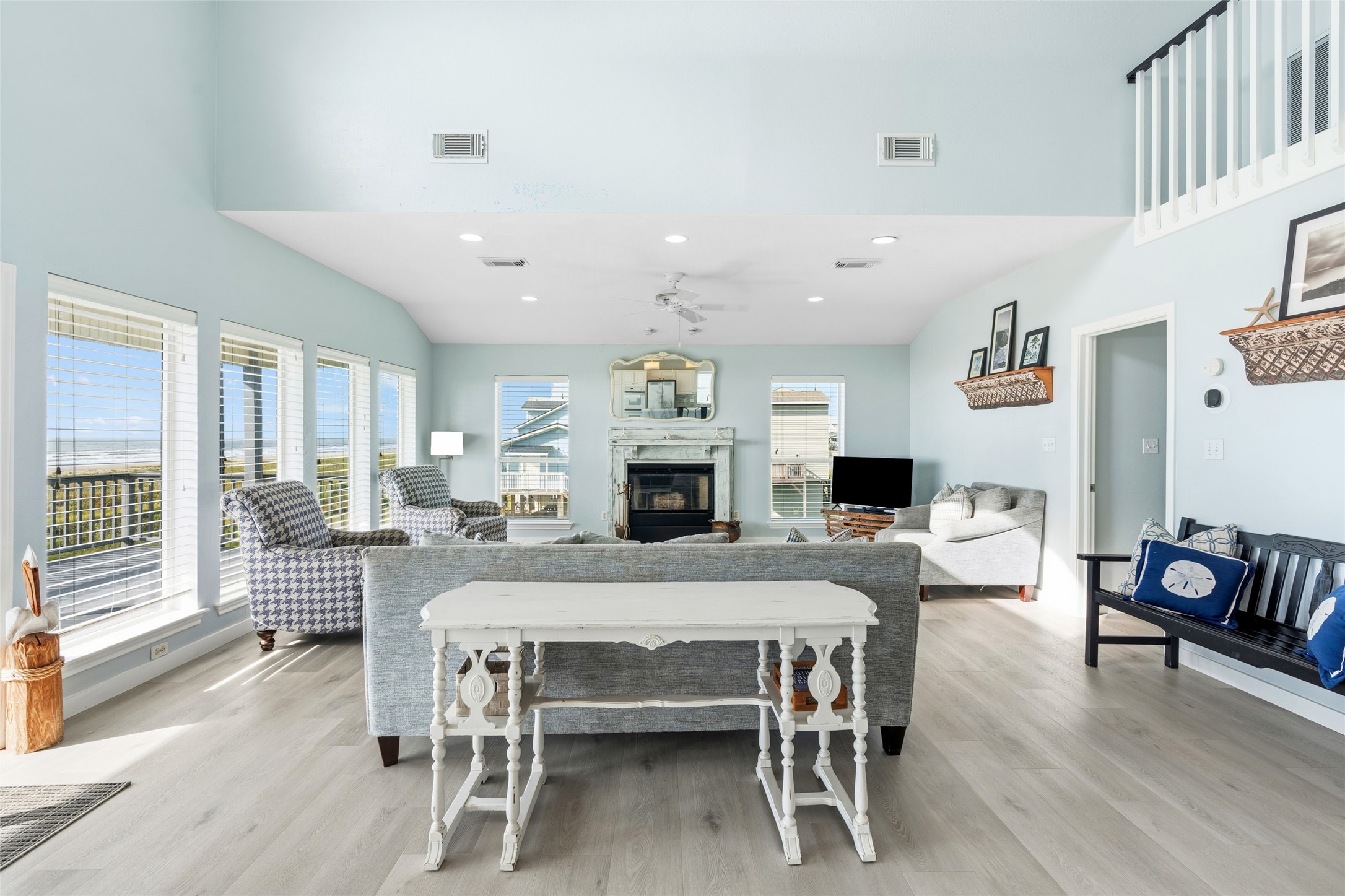 Spacious living room features high ceilings and a cozy fireplace.