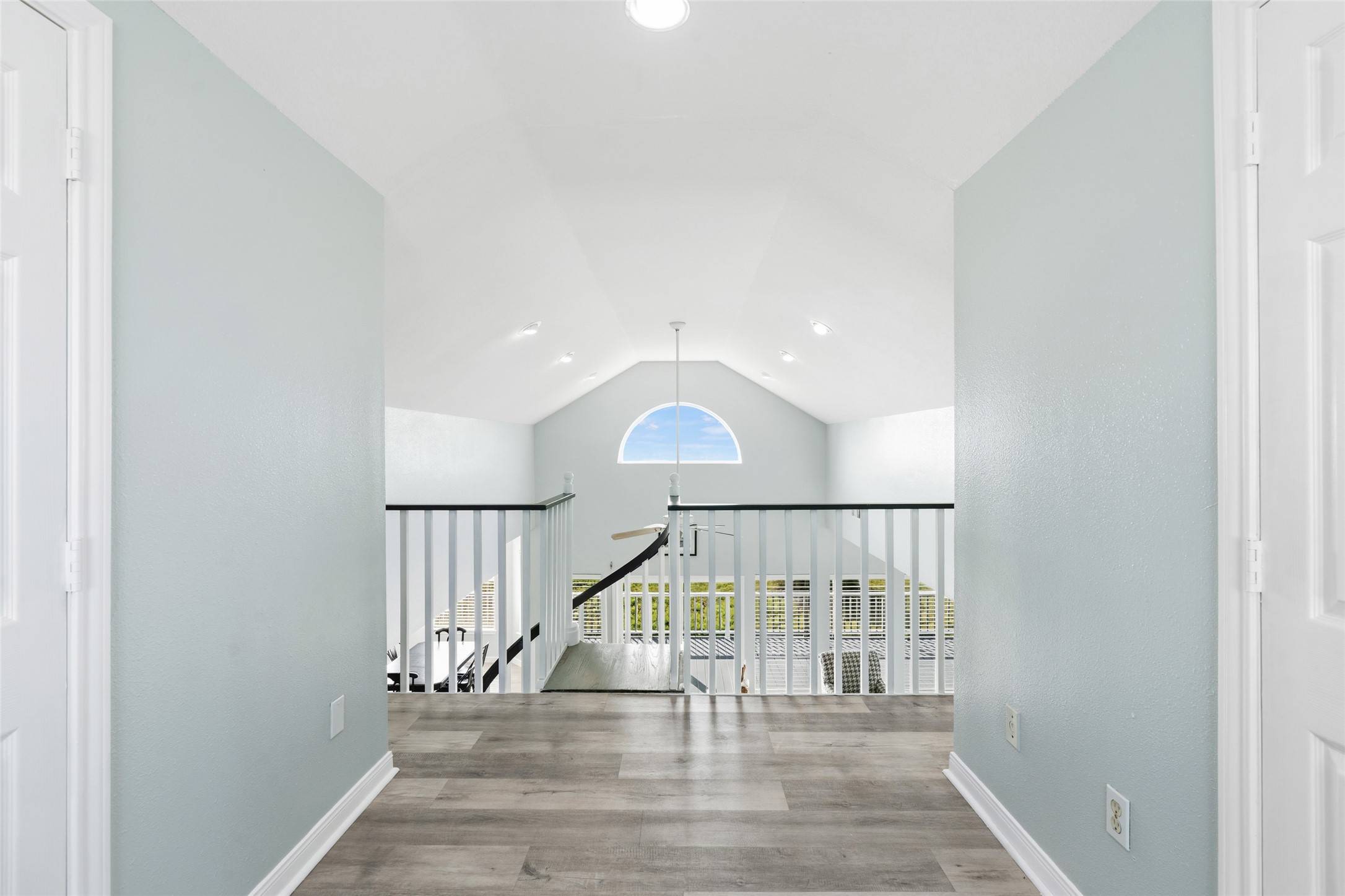 Bright and airy space upstairs features a large arched window that enhances natural light and provides an open feel.