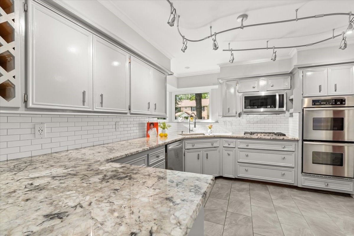Experience a bright, updated kitchen with
expansive quartz countertops, a gas range, double
ovens, and plenty of space to move freely.