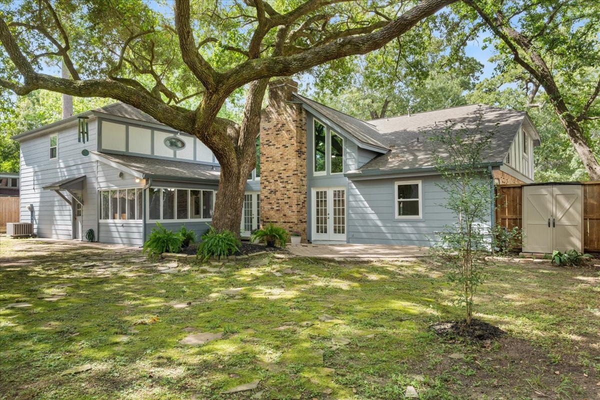 The yard features this lovely tree, patio, screened in sunroom, a small storage shed plus room to add much, much more!