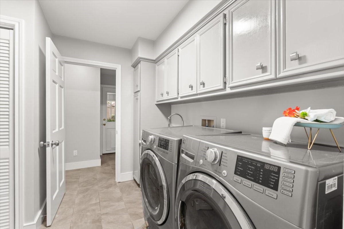 This laundry room is dreamy: it has plenty of storage, a full-sized sink, closet storage and space for an extra refrigerator.