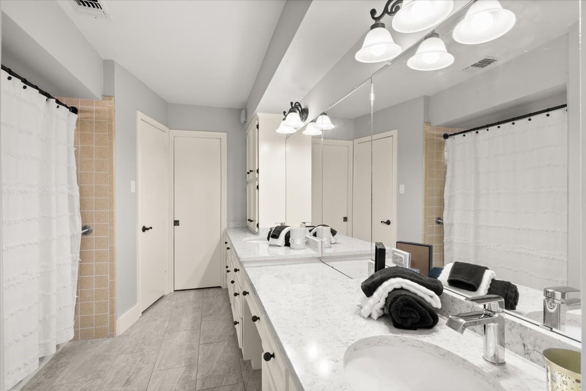 Discover the spacious primary bath featuring
double sinks, ample closets, abundant storage, and
a unique step-down bath/shower.