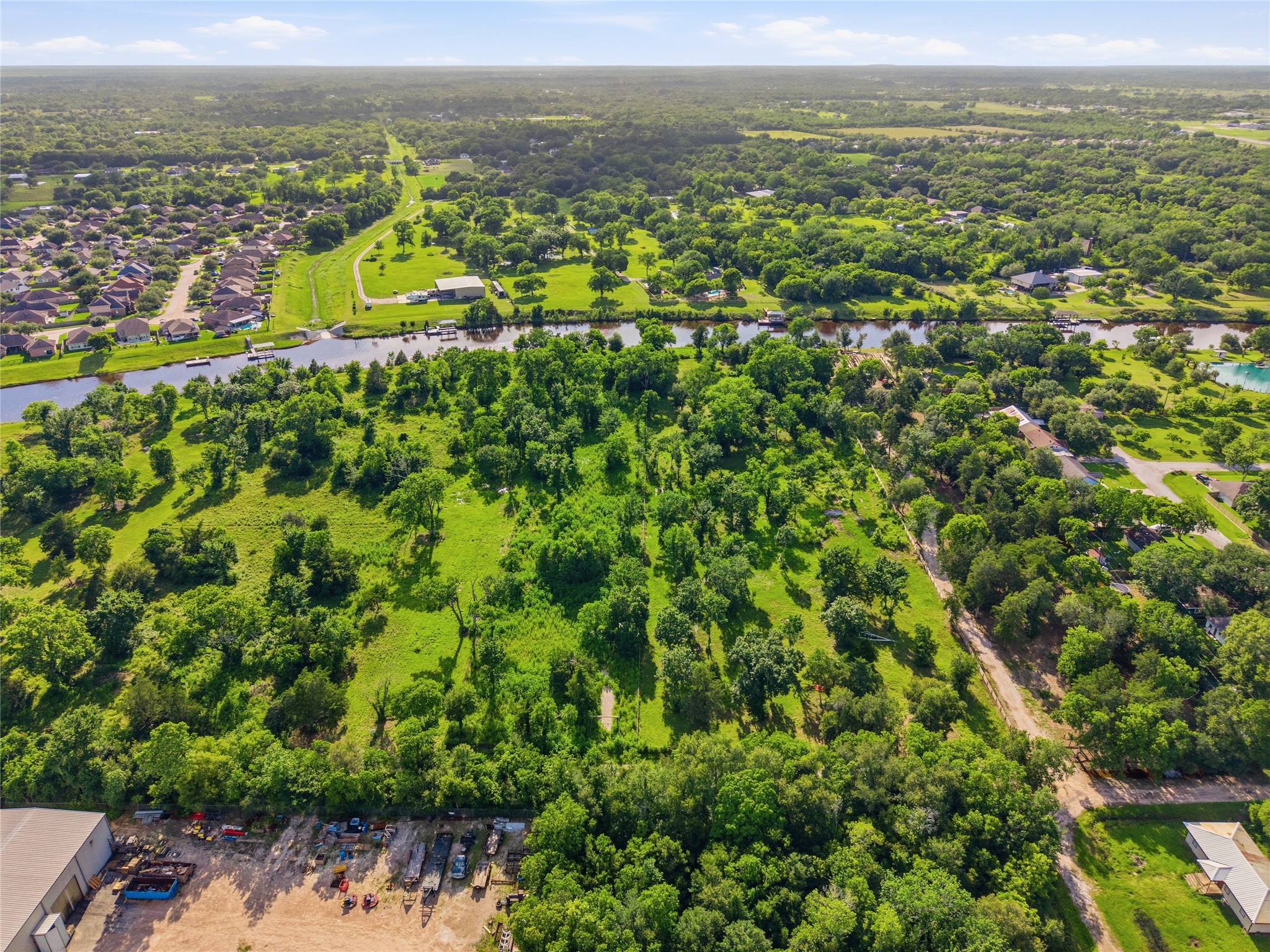 Spacious, lush green lot bordered by a scenic canal.