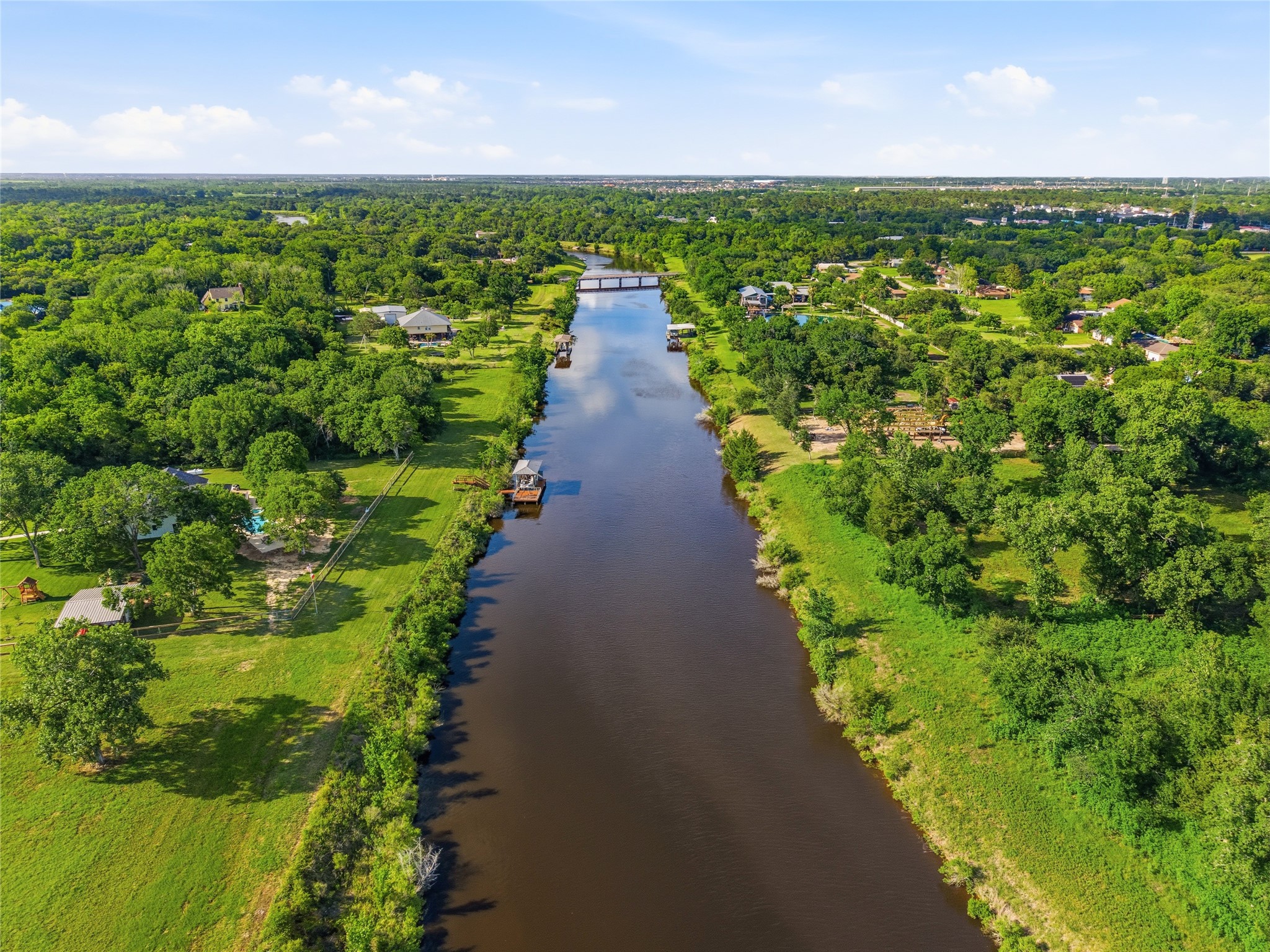 Serene, tree-lined river with nearby residential properties, offering a picturesque and peaceful setting ideal for homeowners seeking a scenic and tranquil environment.
