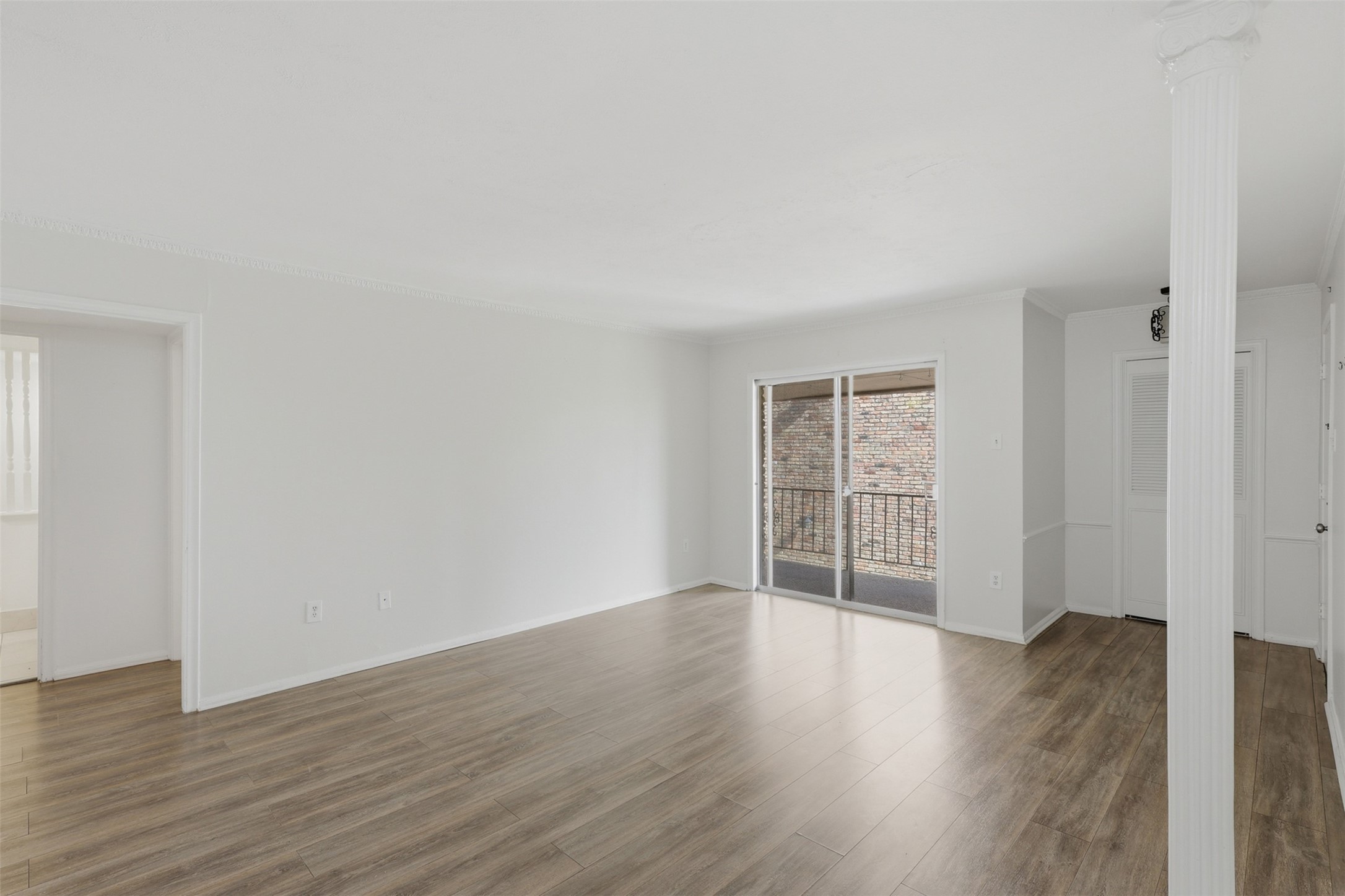 Experience the perfect blend of comfort and style in this spacious living area, featuring elegant hardwood floors and abundant natural light from sliding glass doors leading to a charming balcony.