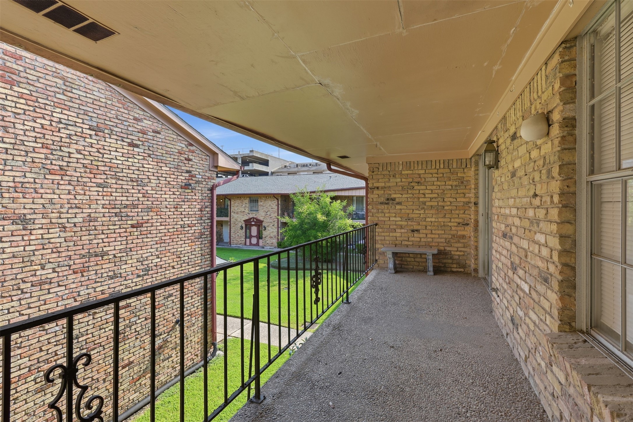 Charming balcony offering a serene view of the courtyard, perfect for relaxing and enjoying the outdoors.