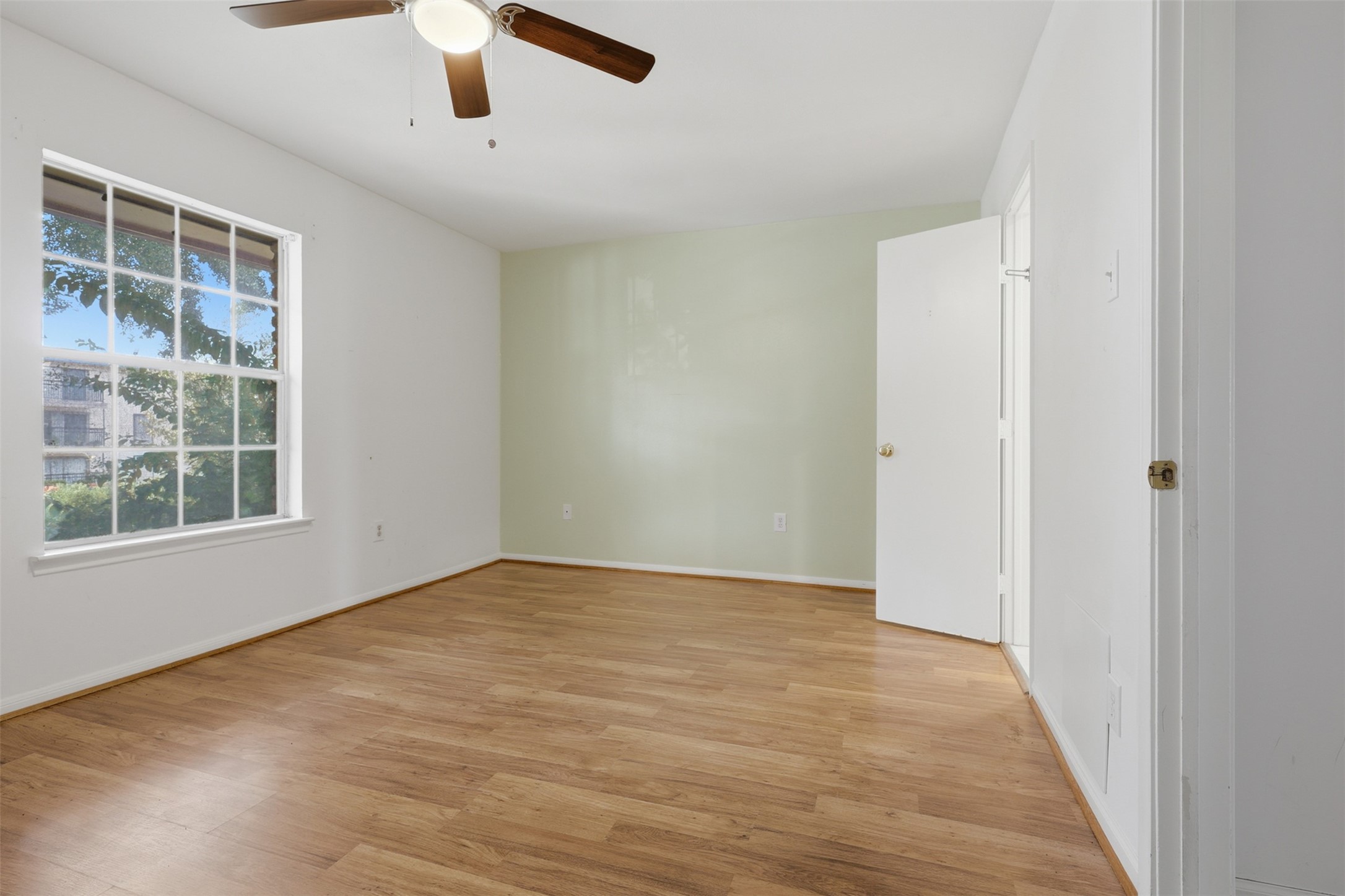 Spacious and serene, the primary bedroom boasts abundant natural light, warm wood flooring, and a calming neutral palette, perfect for relaxation. Spacious and serene, the primary bedroom boasts abundant natural light, warm wood flooring, and a calming neutral palette, perfect for relaxation.