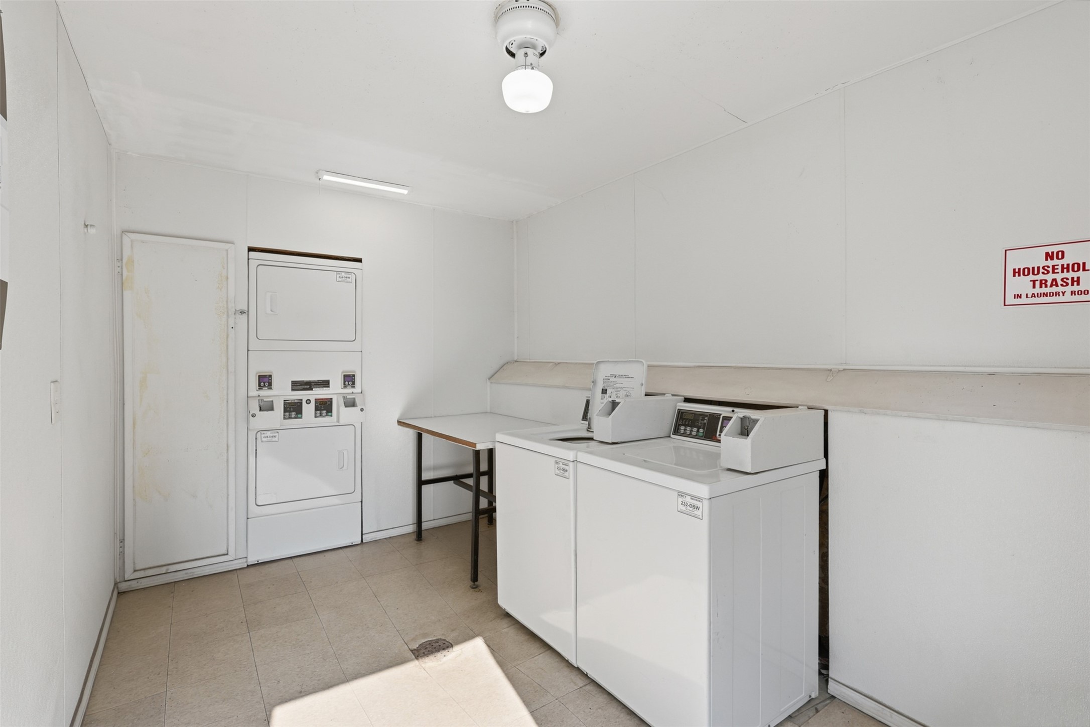 Efficient and functional, this laundry room features modern stacked units and ample folding space, streamlining your daily chores with ease.
