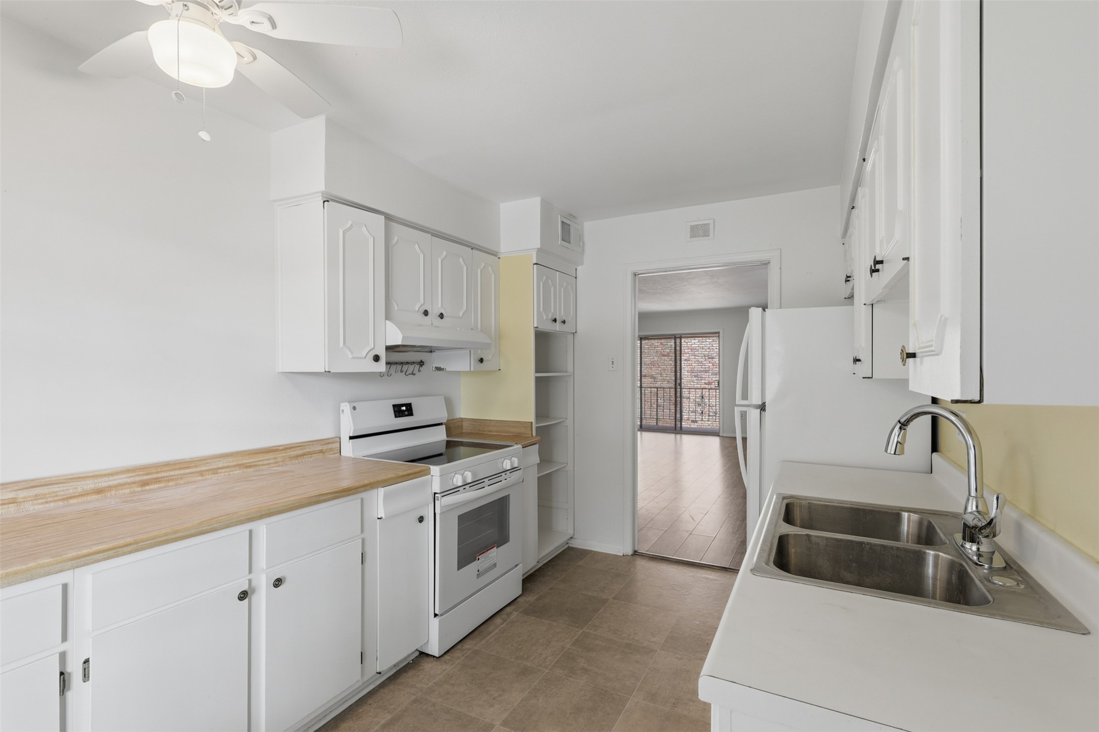 Bright and inviting, this kitchen features classic white cabinetry, ample counter space, and modern appliances, seamlessly connecting to the living area for easy entertaining. Bright and inviting, this kitchen features classic white cabinetry, ample counter space, and modern appliances, seamlessly connecting to the living area for easy entertaining.