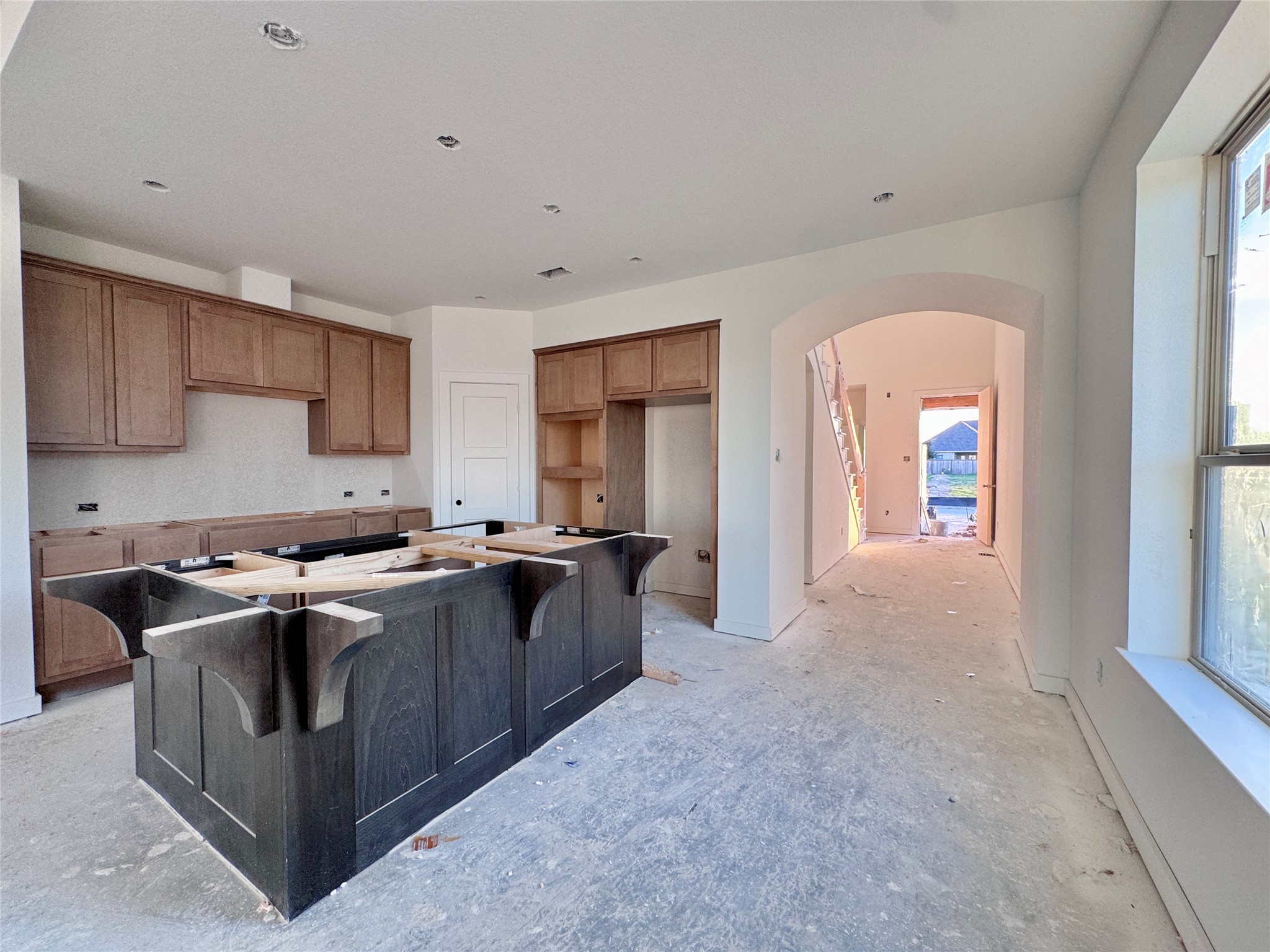 Once you make your way down the entry hall, through the arch, picture a massive island to your right! The kitchen opens up to the dining and family room.