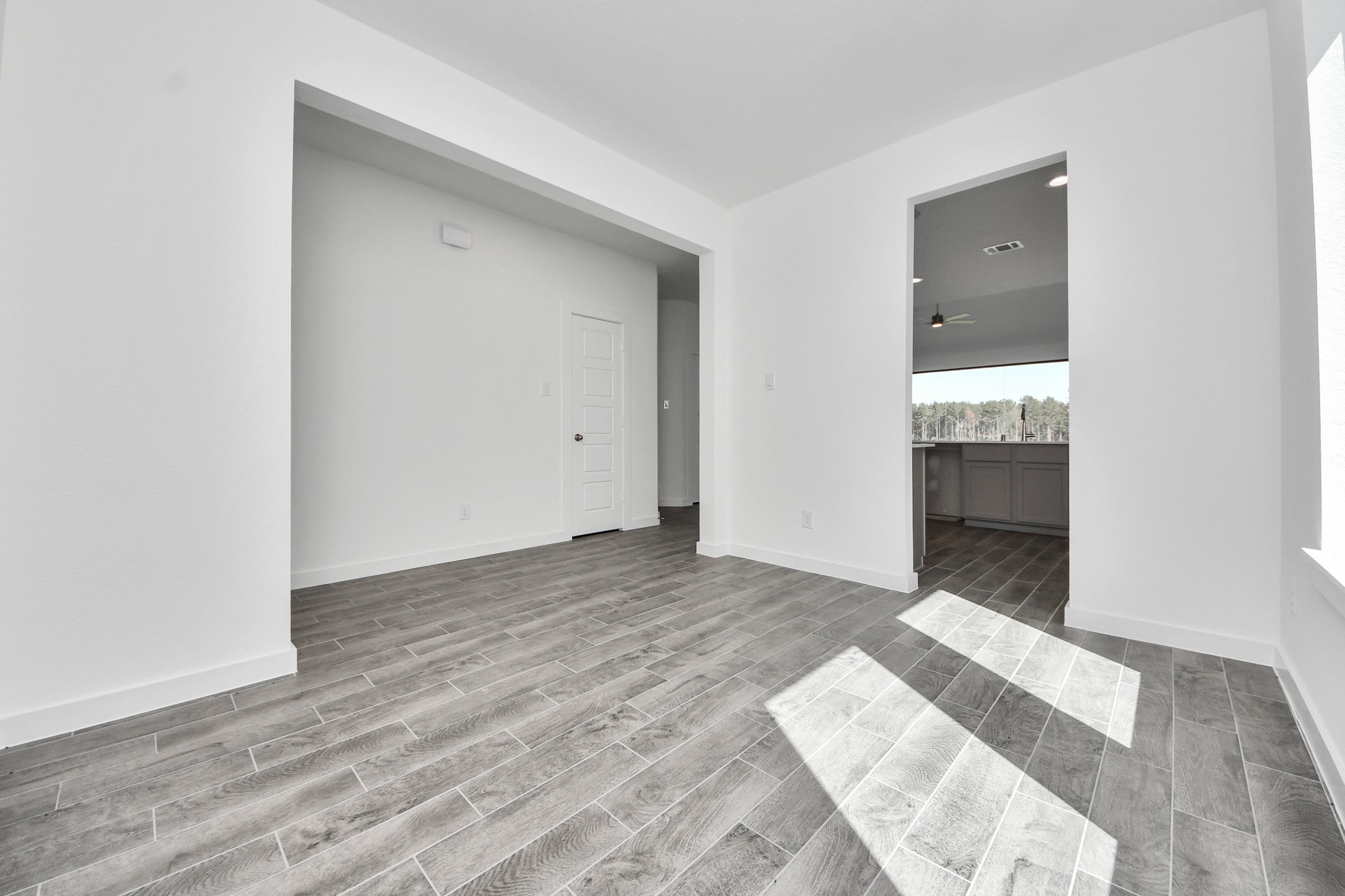 Create lasting memories with your family and friends at the dining table! This expansive dining room showcases sophisticated flooring, custom paint, and seamlessly connects to the family room and kitchen, providing an open and inviting atmosphere
