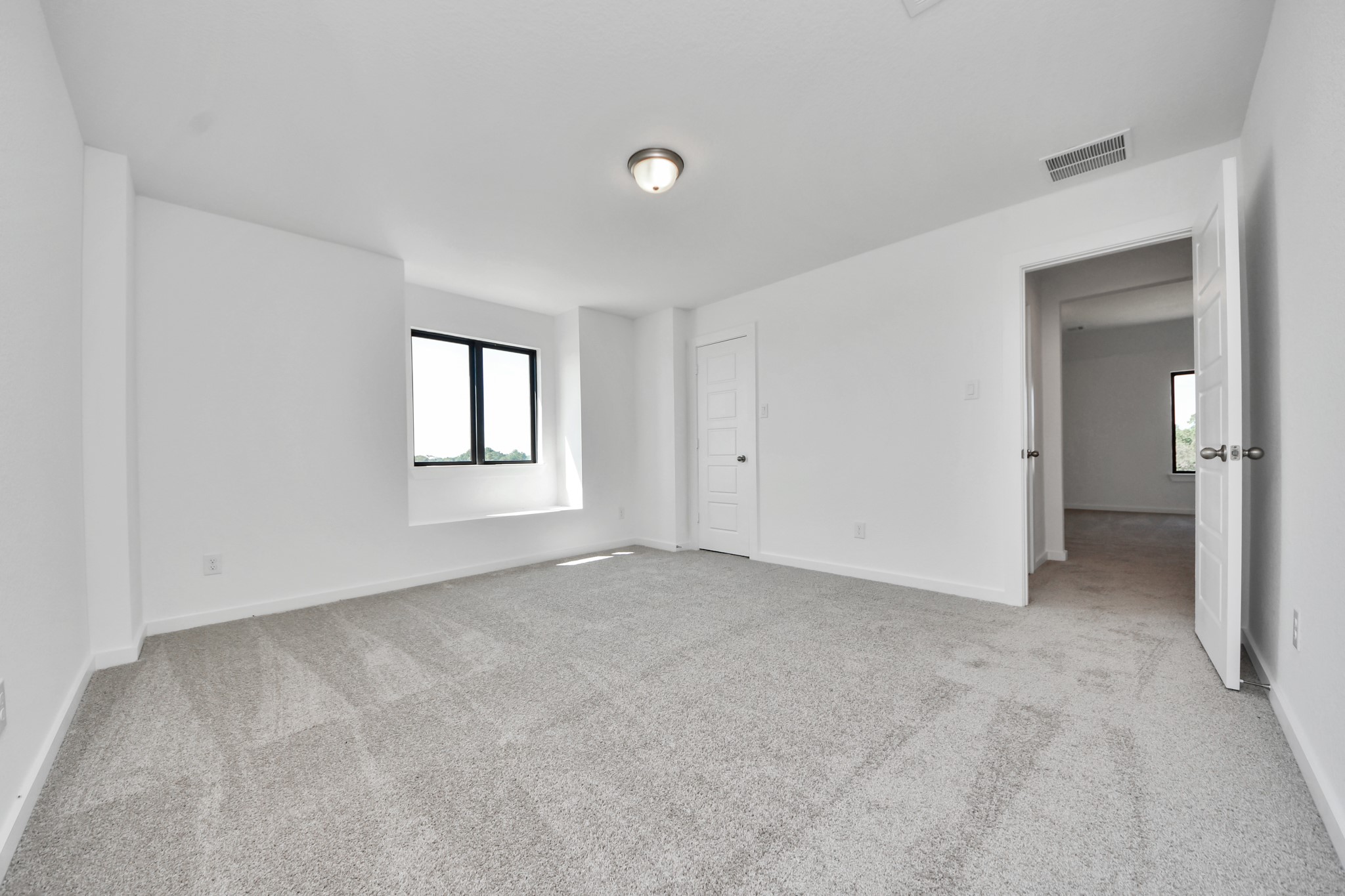Secondary bedroom features plush carpeting, large windows that let in plenty of natural light, bright paint, and spacious closets.