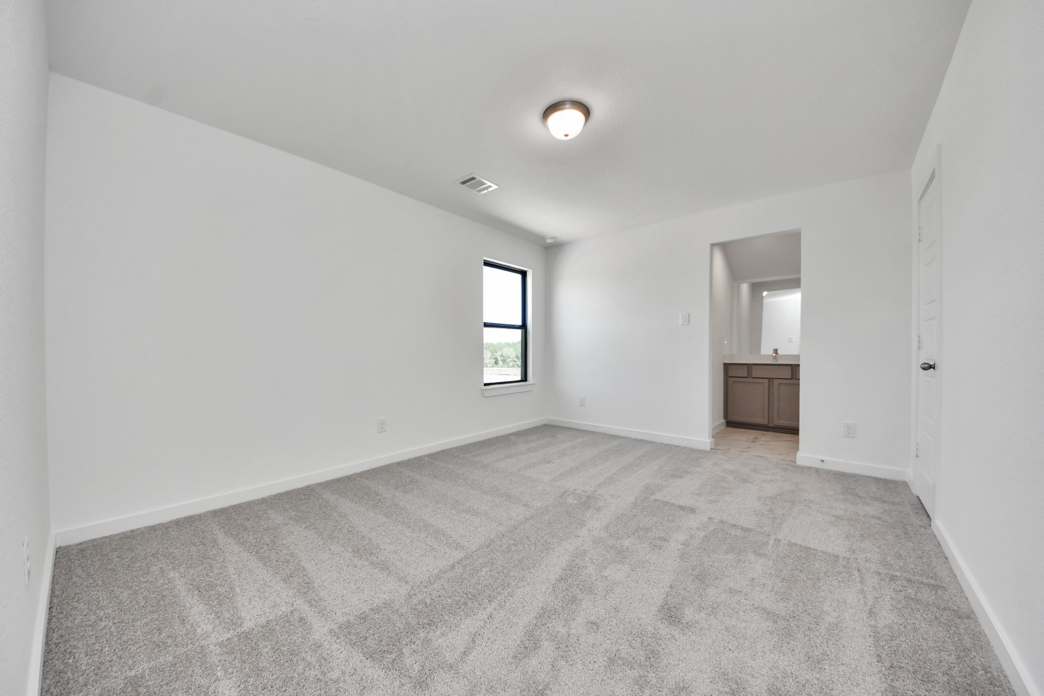 Secondary bedroom features plush carpeting, large windows that let in plenty of natural light, bright paint, and spacious closets.