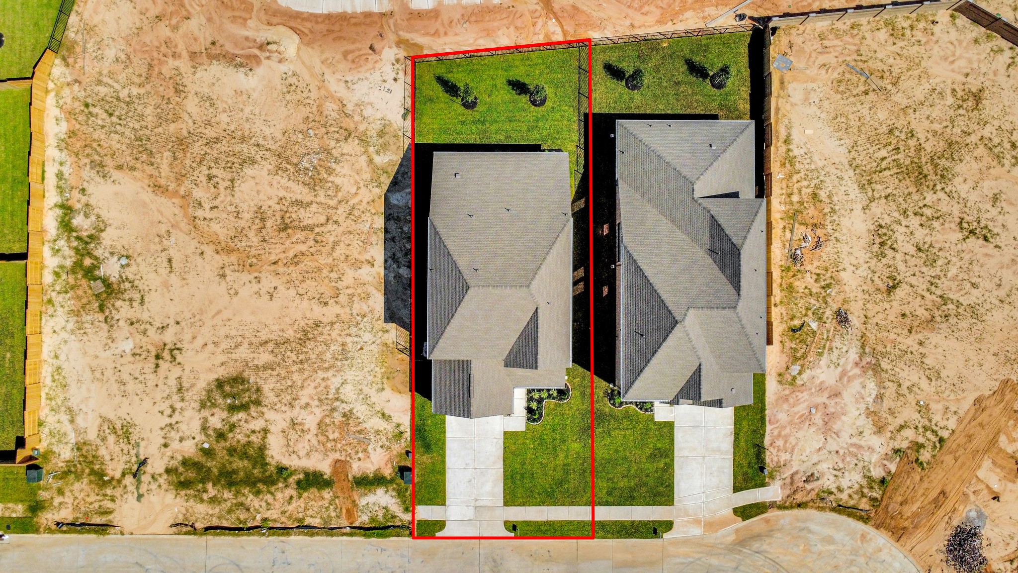 An aerial view of a spacious subdivision lot, highlighting a well-maintained yard and a fully fenced perimeter, offering both privacy and expansive outdoor space.