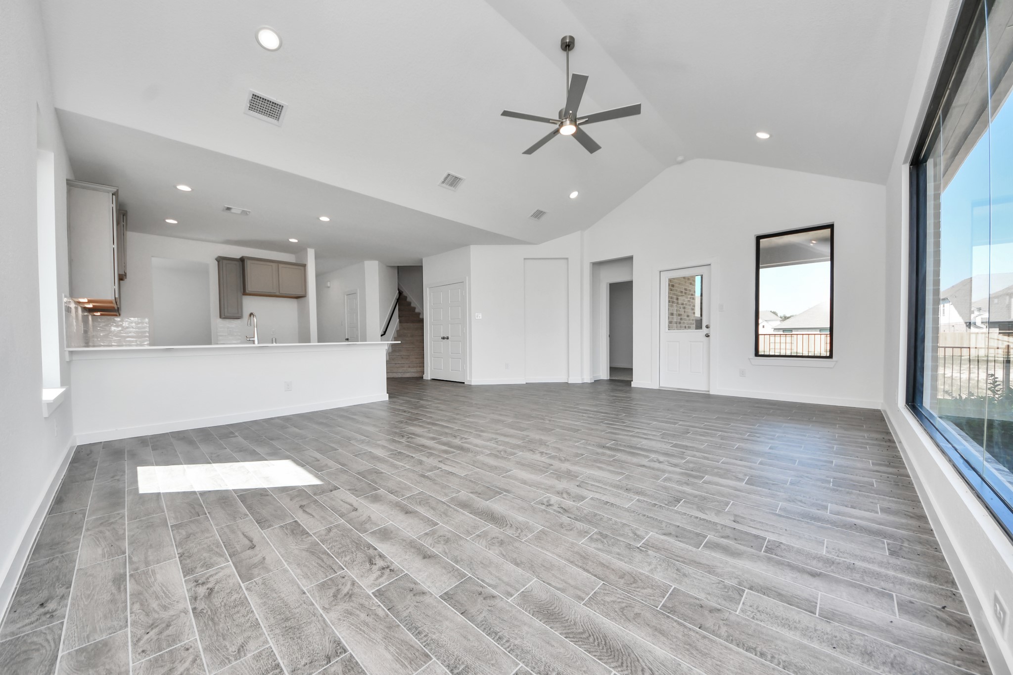 Gather the family and guests together in your lovely living room! Featuring soaring high ceilings, recessed lighting, ceiling fan, custom paint, gorgeous floors, and large windows that provide plenty of natural lighting throughout the day.