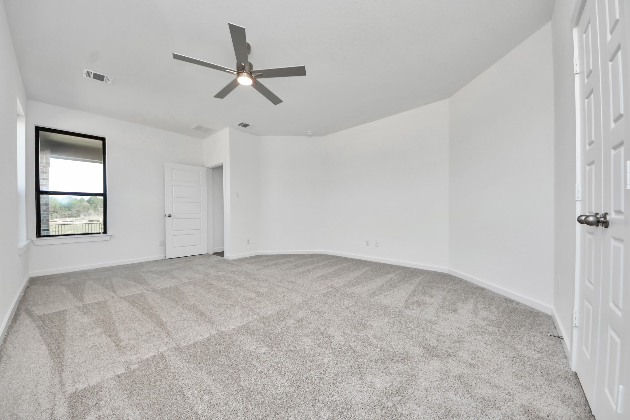 Retreat to the luxurious primary suite, your perfect escape for unwinding after a long day. Located on the first floor, this spacious room features plush carpeting, calming paint tones, high ceilings, and large windows with privacy blinds.