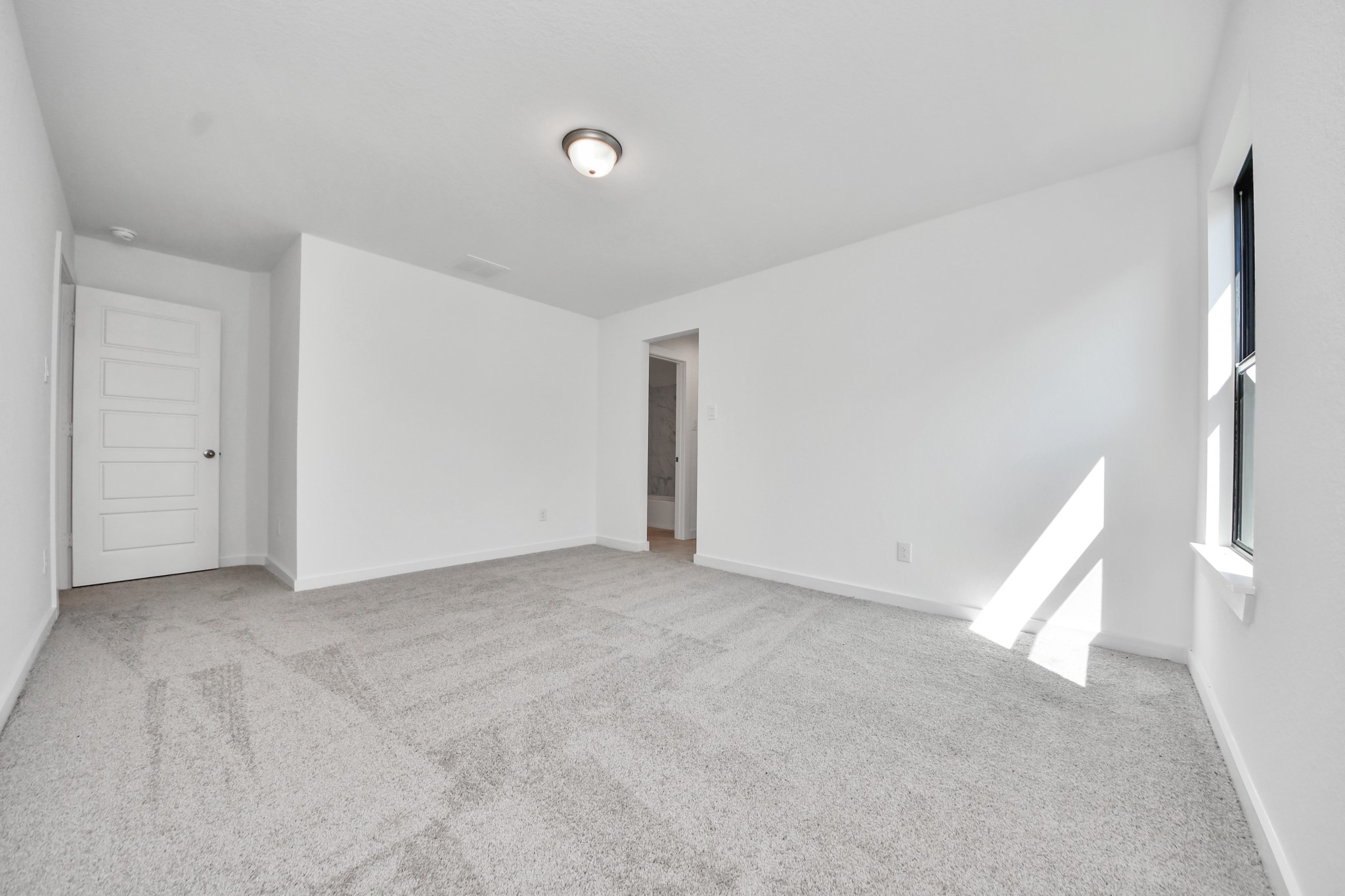 Secondary bedroom features plush carpeting, large windows that let in plenty of natural light, bright paint, and spacious closets.