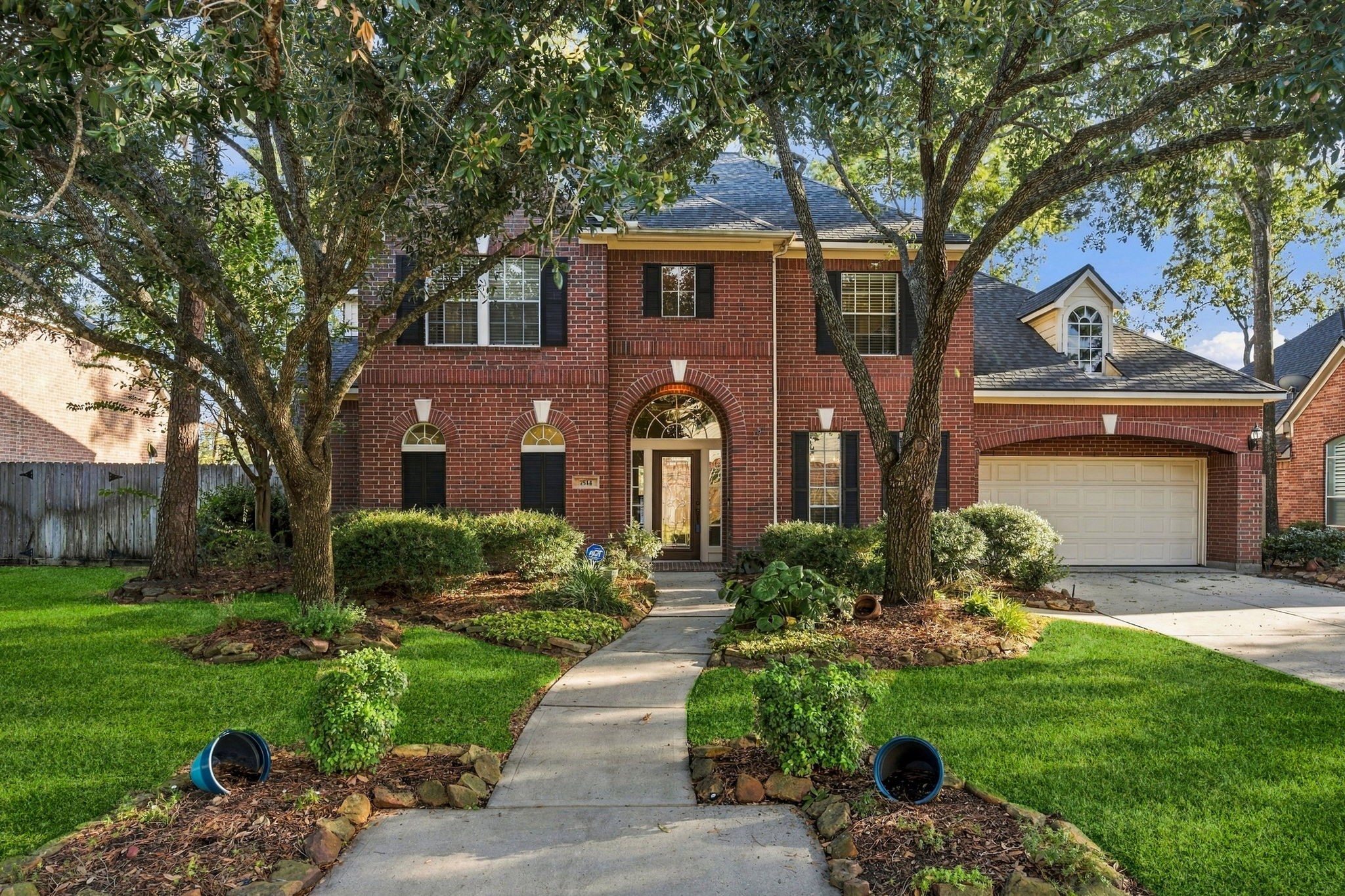 Stately brick home with charming arched windows and a welcoming front path, nestled among mature trees and lush landscaping. Stately brick home with charming arched windows and a welcoming front path, nestled among mature trees and lush landscaping.