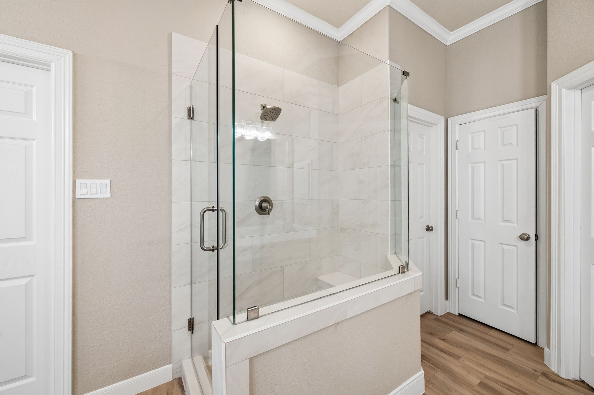 Elegant updated primary bathroom featuring a modern glass-enclosed shower