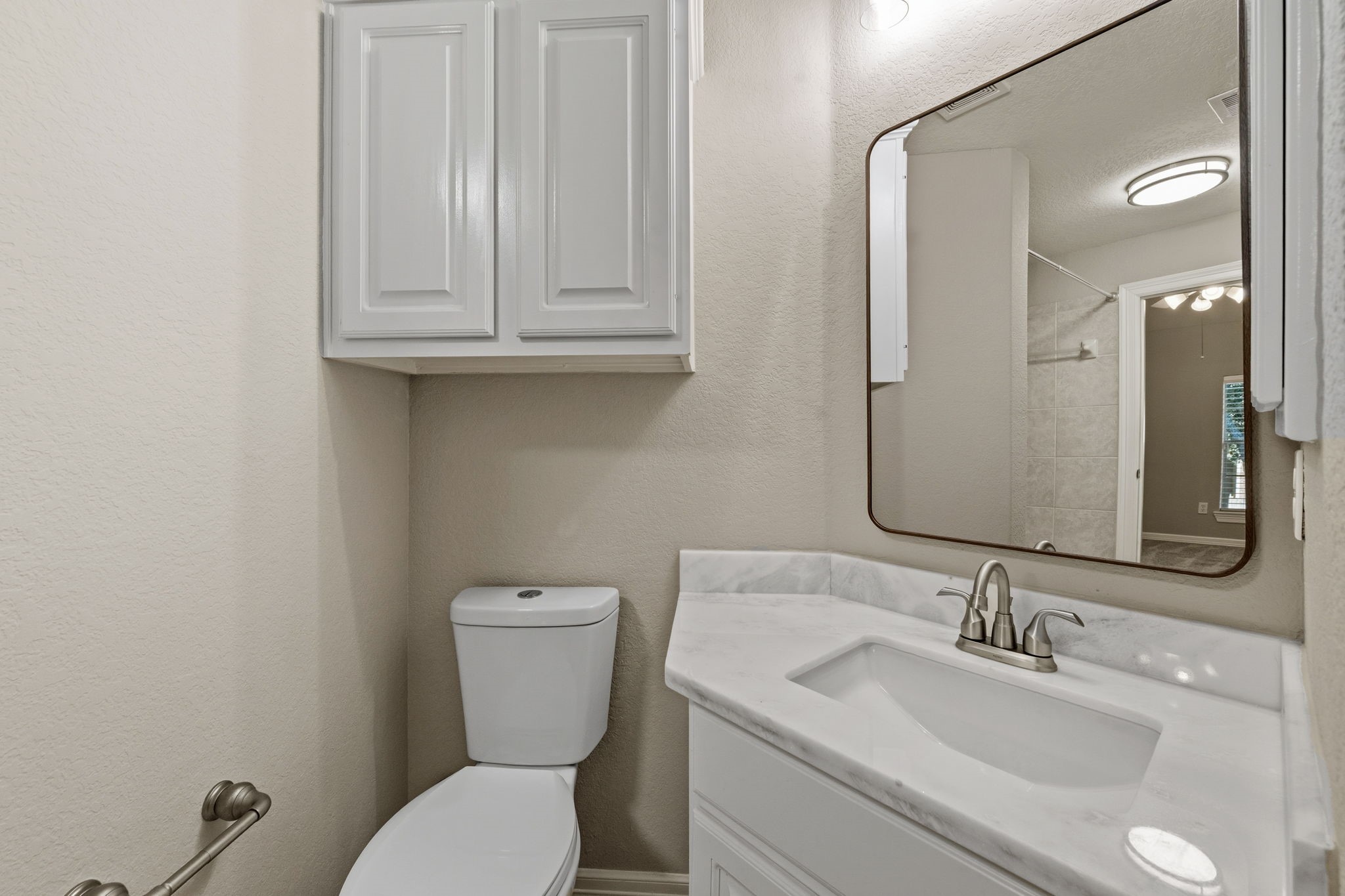 Charming bathroom featuring a sleek vanity with a updated countertop, ample cabinet storage, and stylish fixtures.