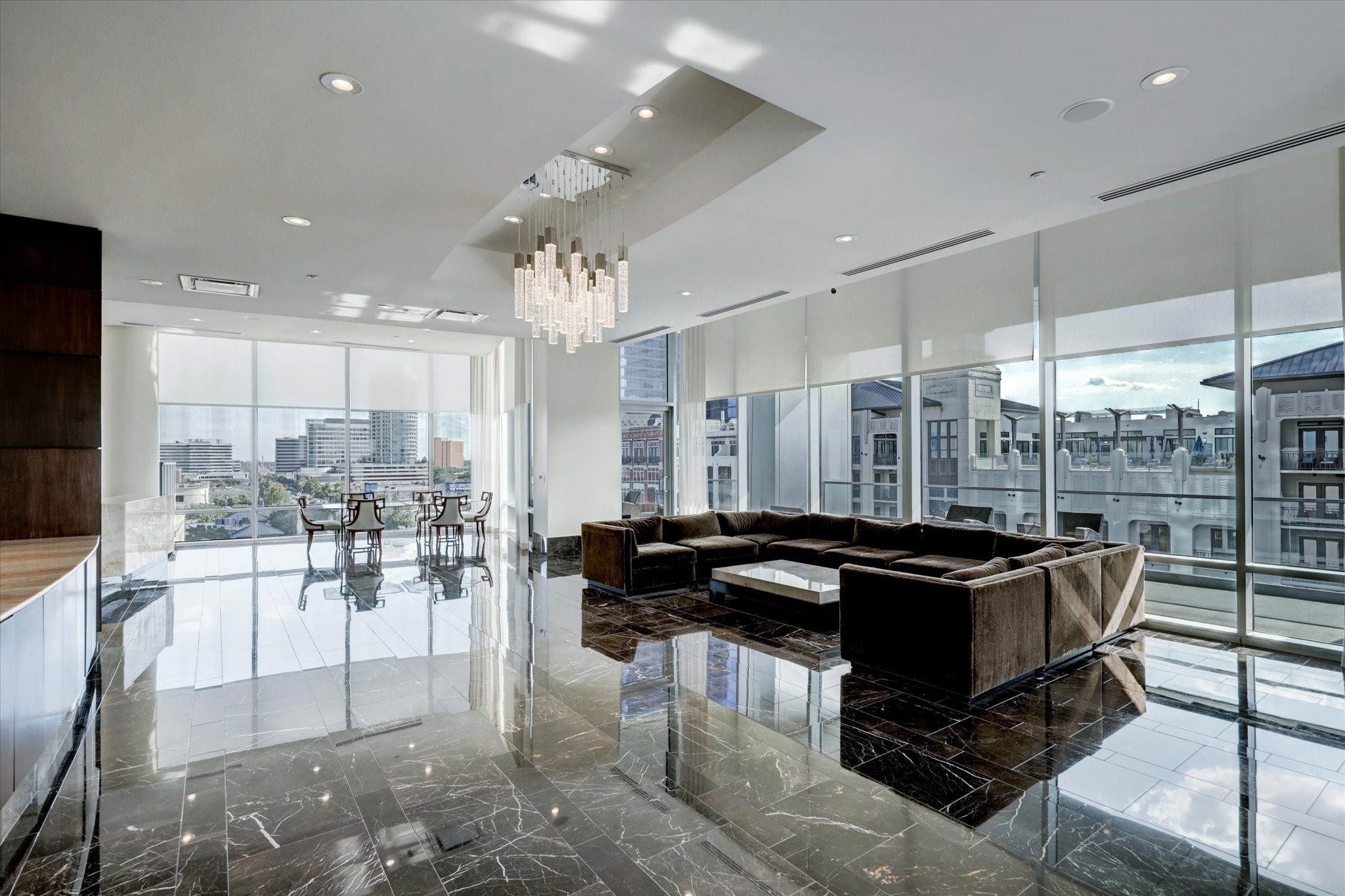Secondary lounge with marble flooring, floor-to-ceiling windows, and contemporary lighting.