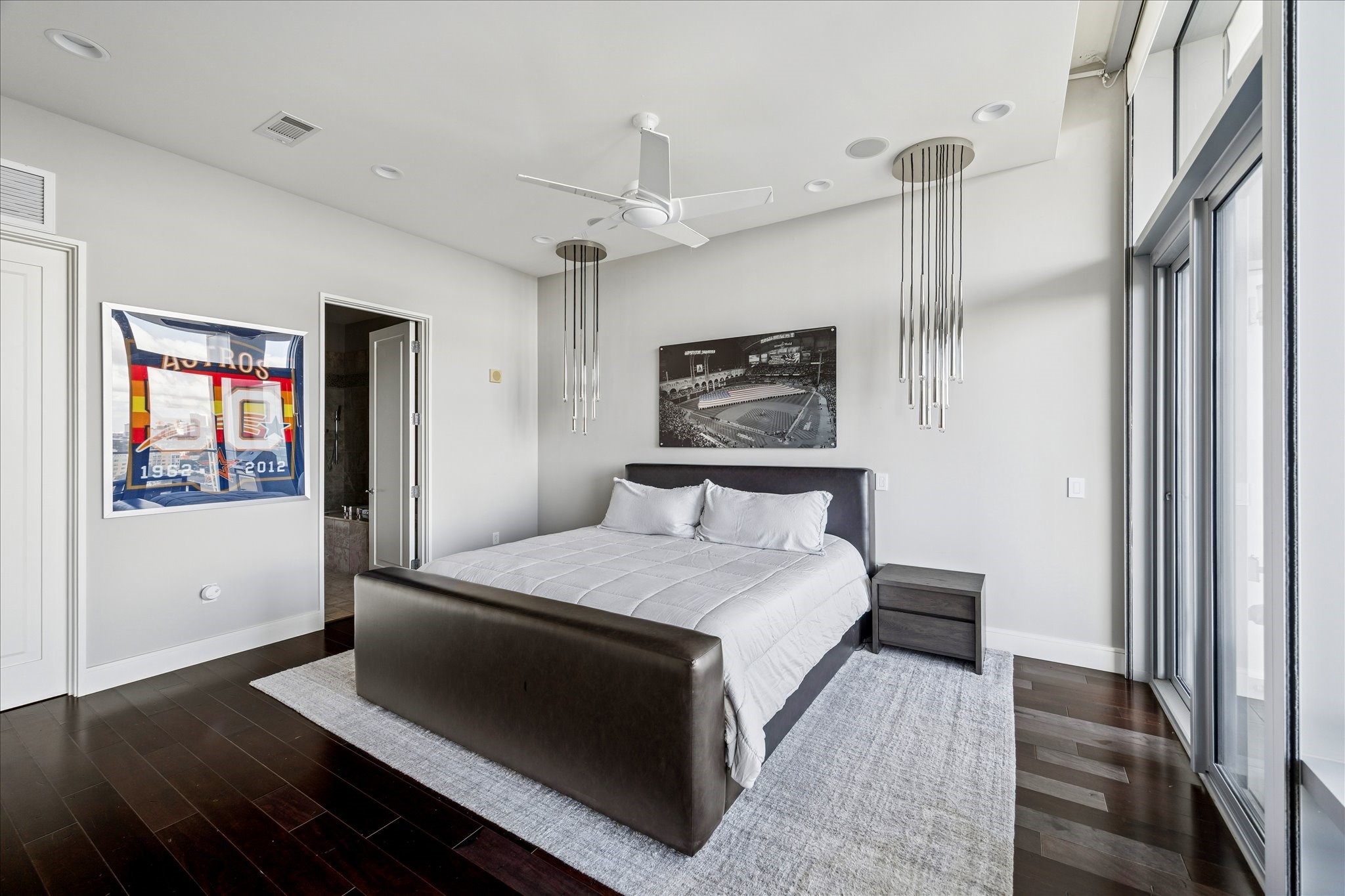 Primary bedroom with hardwood floors, recessed lighting, and access to ensuite bath and private terrace.