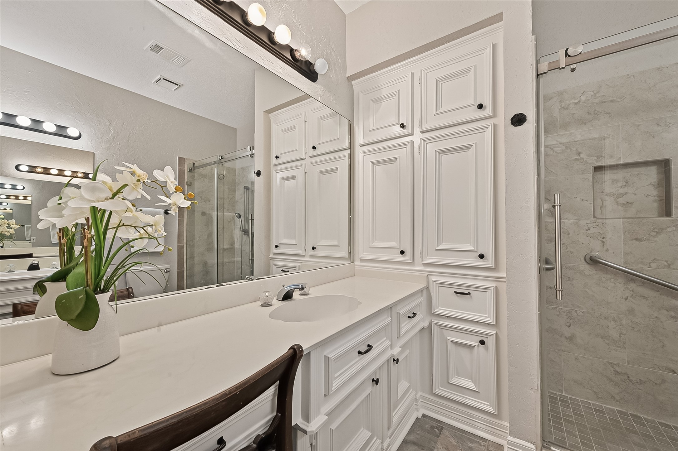 This 2nd Full bathroom offers dual vanities and custom built in cabinets.
