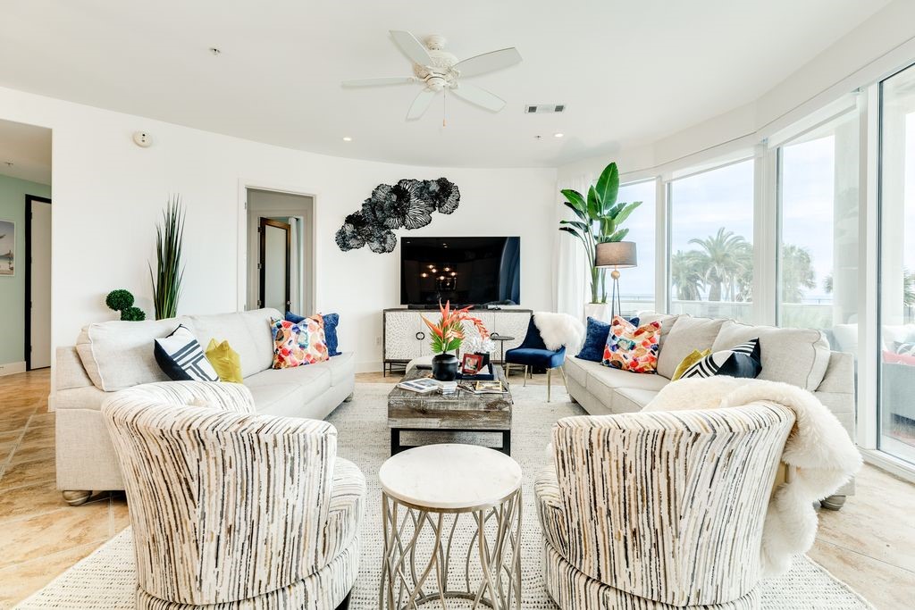 Beautifully appointed living room with a wall of curved windows overlooking the pools Beautifully appointed living room with a wall of curved windows overlooking the pools