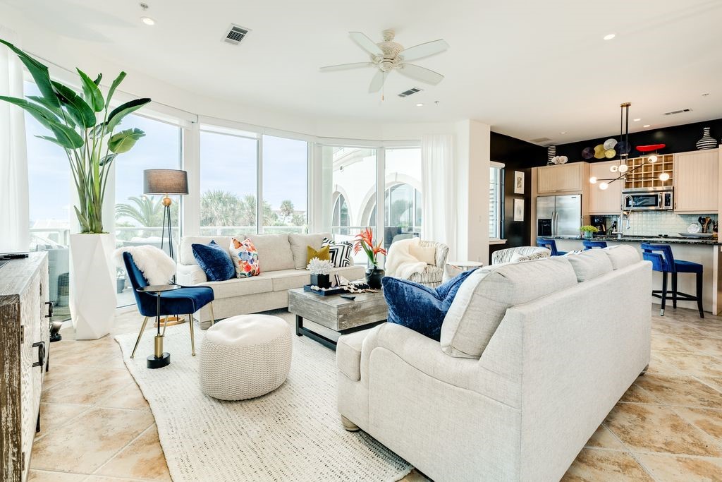 Living area with wall of curved windows with access to large balcony