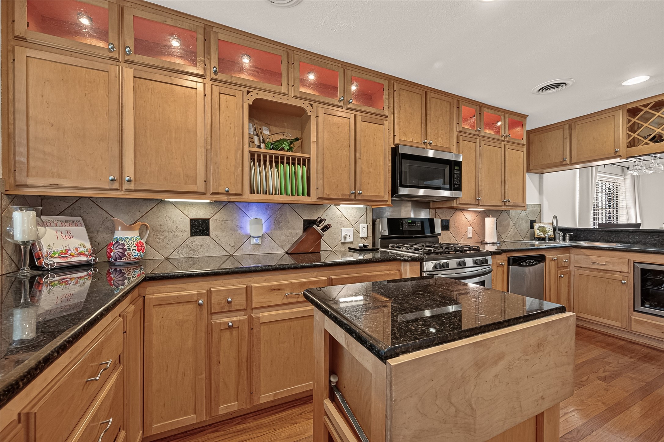 Granite counters,Tile back splash and under counter lighting.Extra cabinets over the Breakfast bar. Split under counter mount kitchen sink.