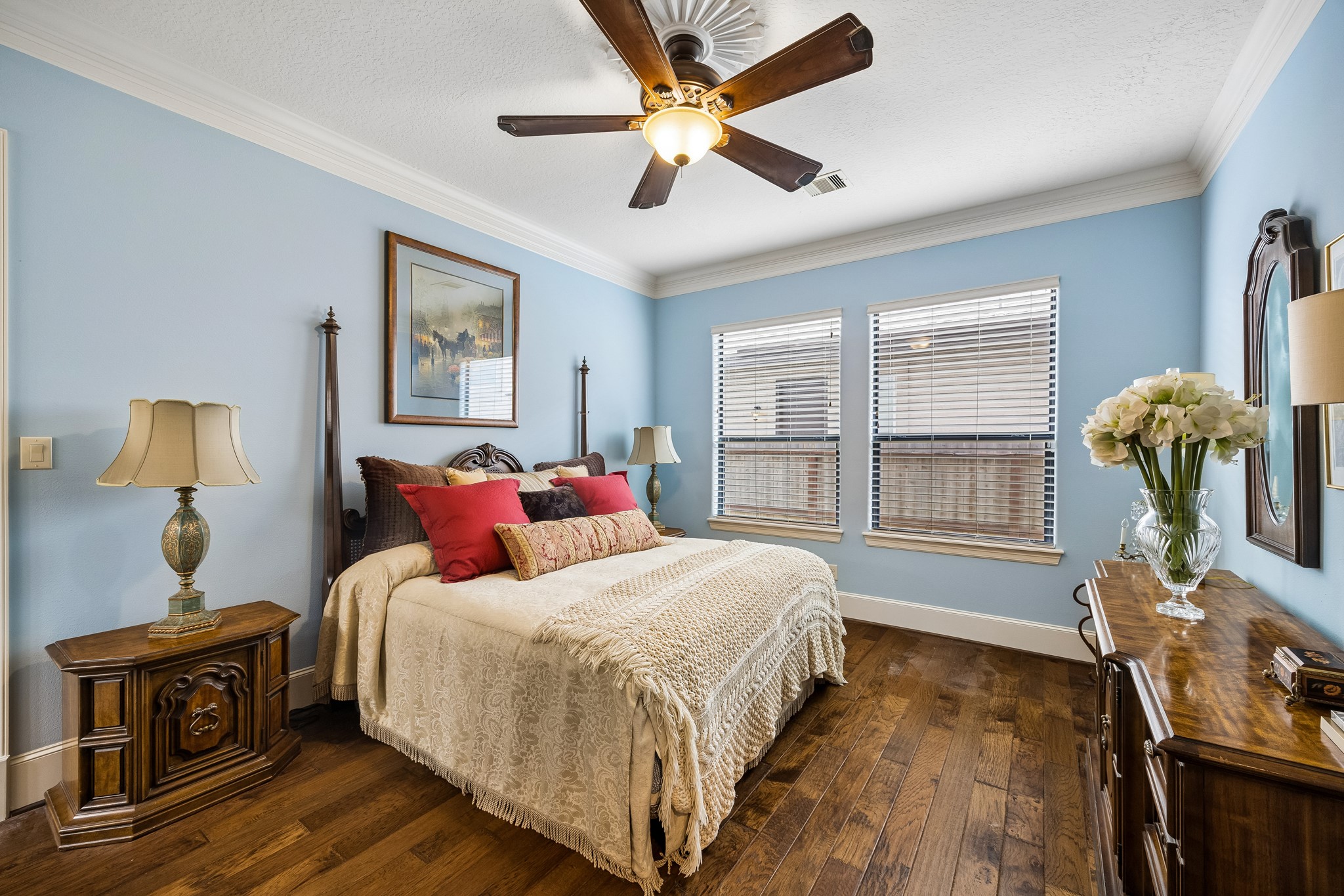 Charming first floor en-suite bedroom with soft blue walls, elegant wooden floors, and abundant natural light.