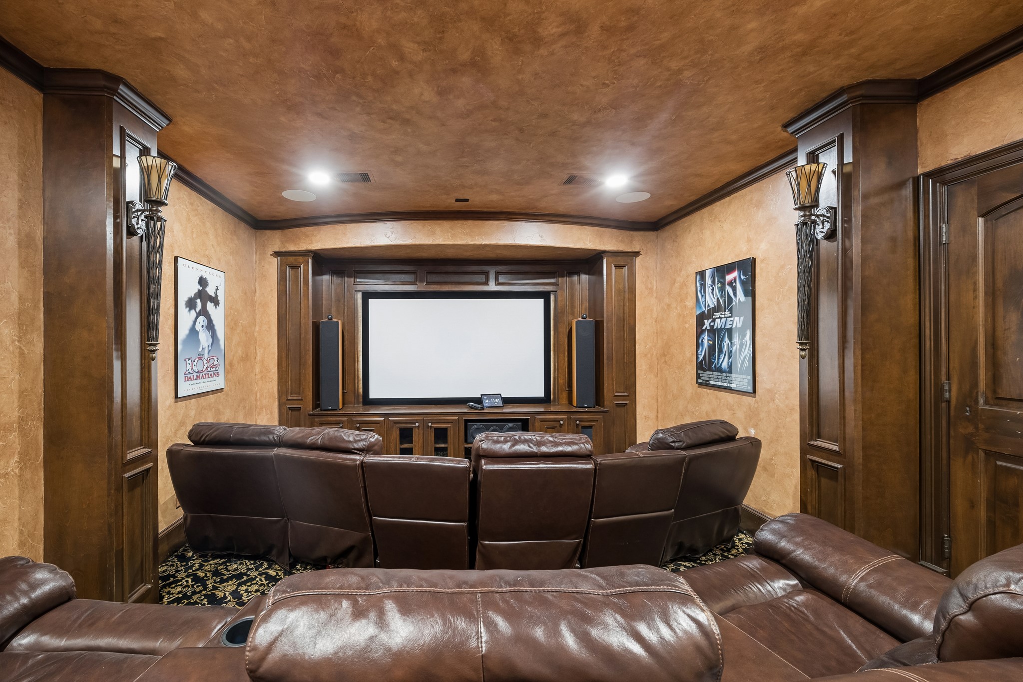 Luxurious home theater with top-of-the line AV equipment features plush leather recliners, rich wood paneling, and a large screen for the ultimate cinematic experience.