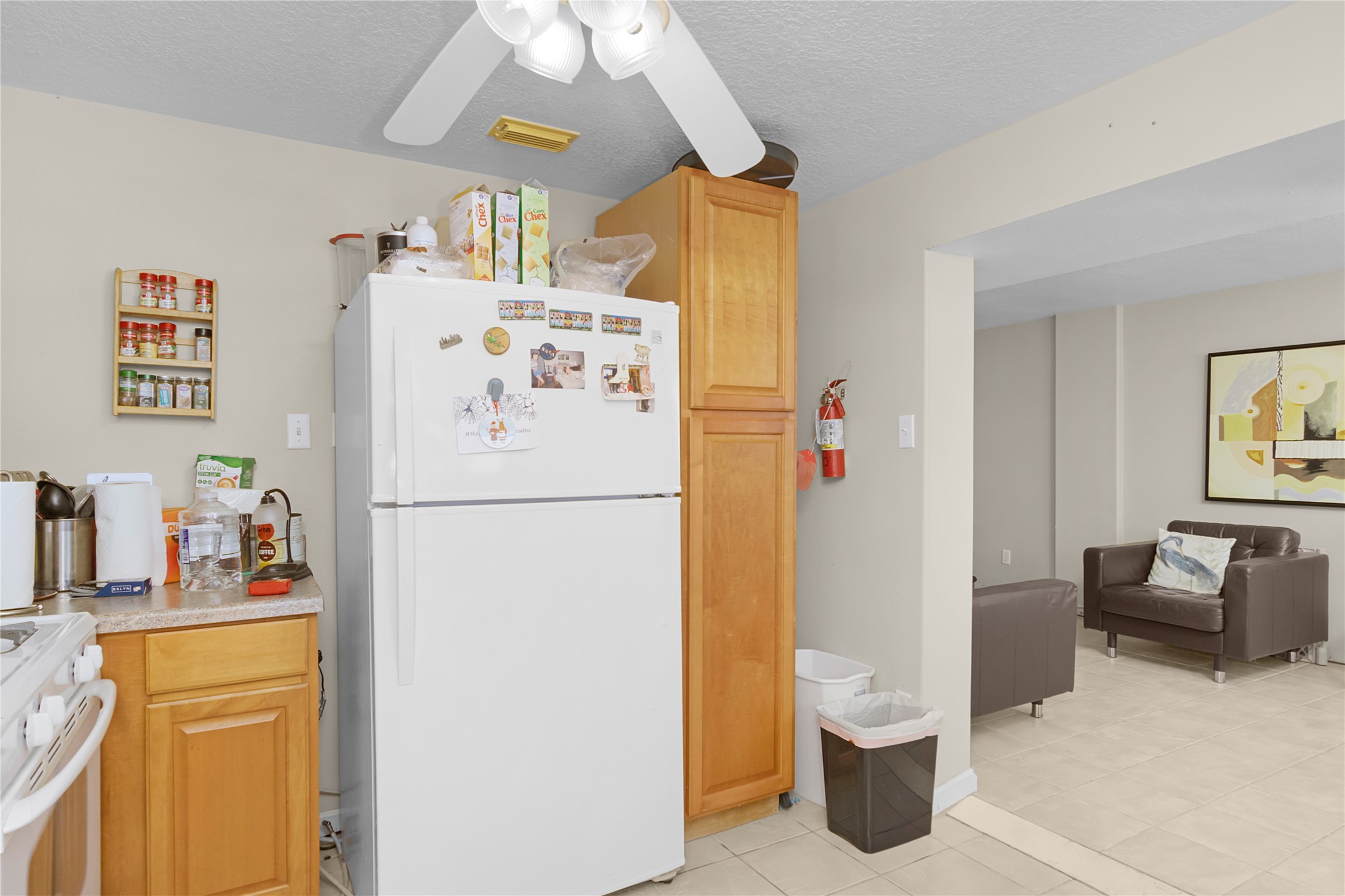 Refrigerator, pantry in quarters and view of living room on left side.