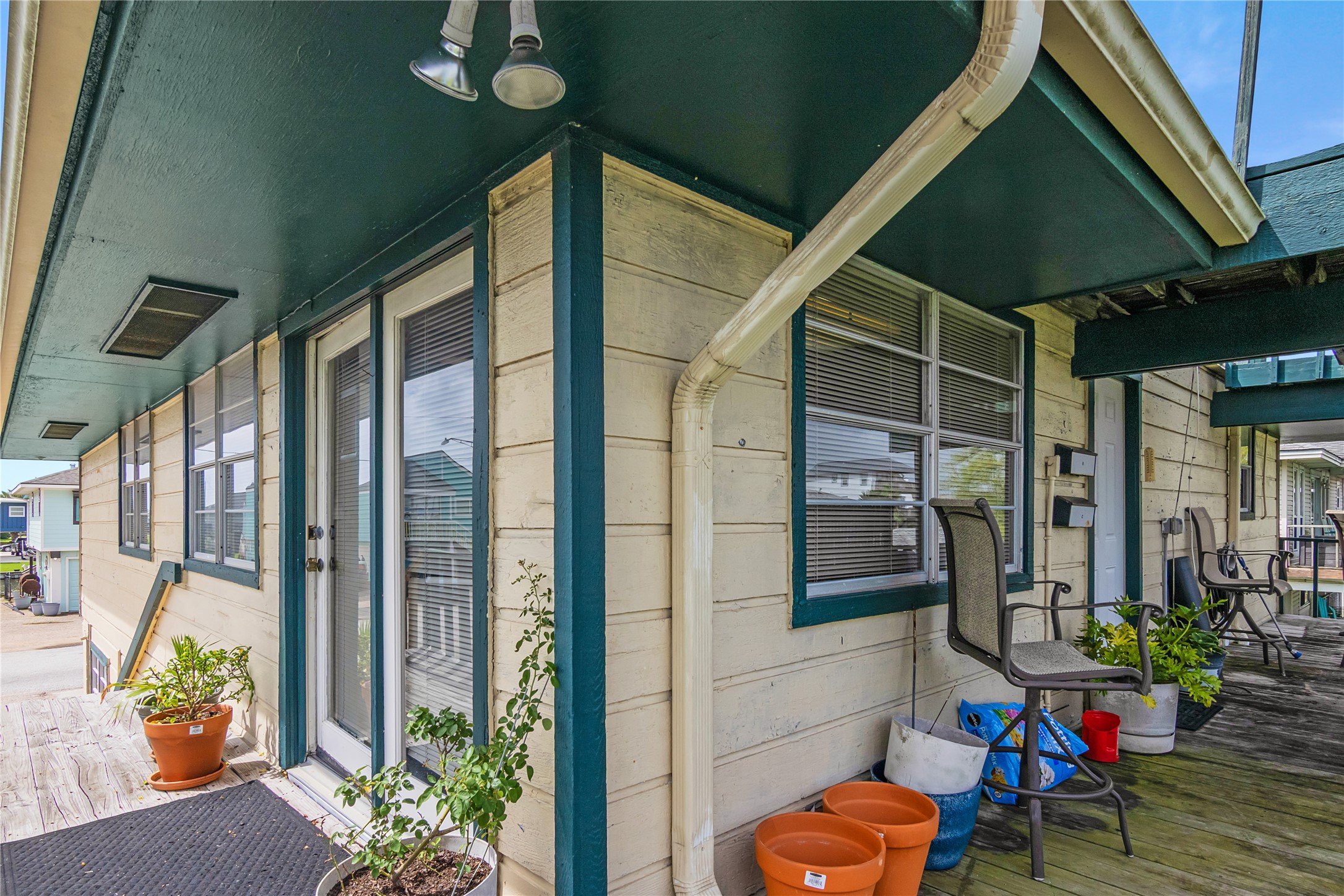 Exterior picture showing French door entrance, second entry door, large windows and deck.