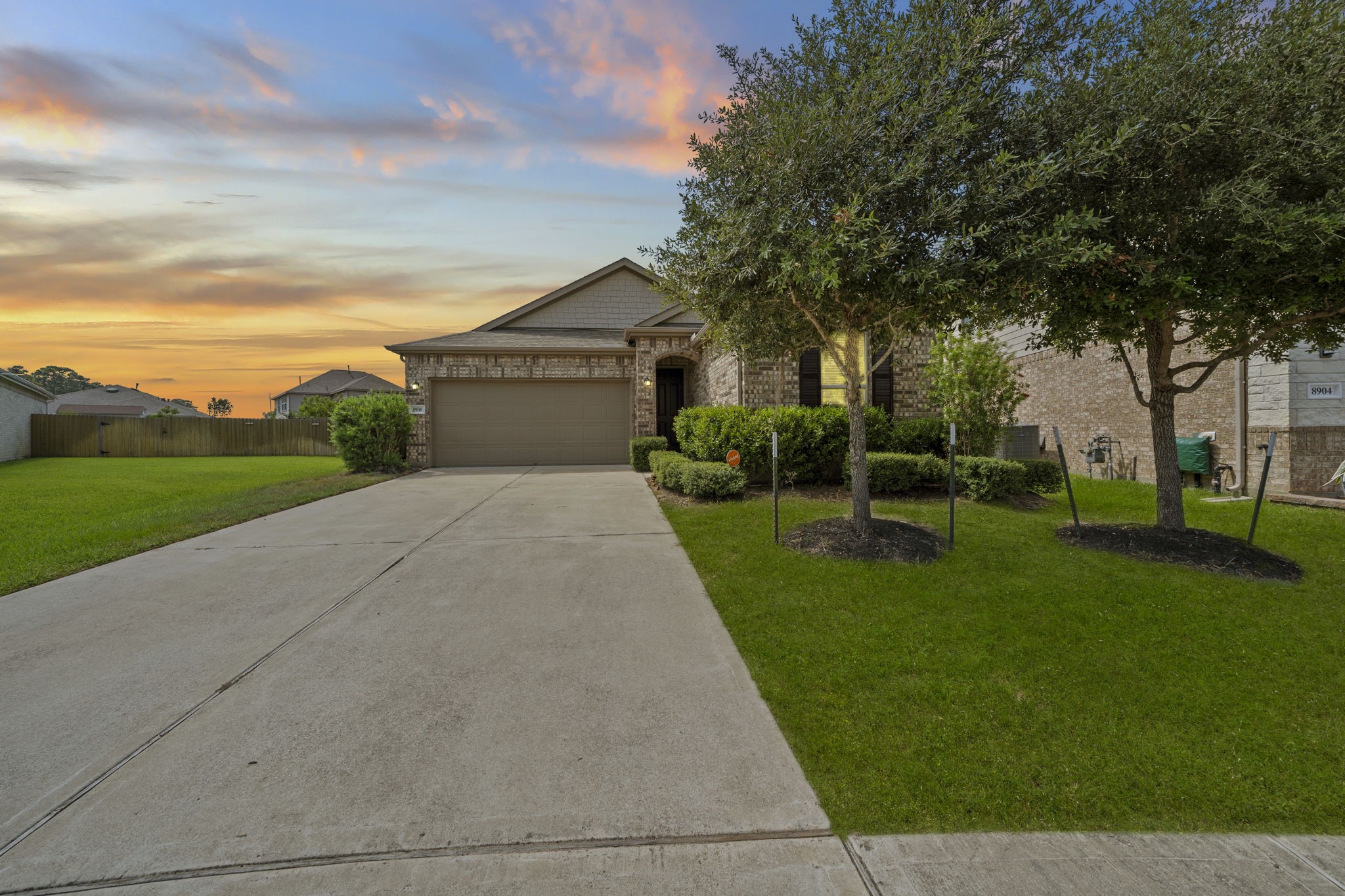 Charming curb appeal awaits you at this beautiful brick home, featuring mature trees and manicured landscaping. The long, double-wide driveway leads to a two-car garage, offering ample parking.