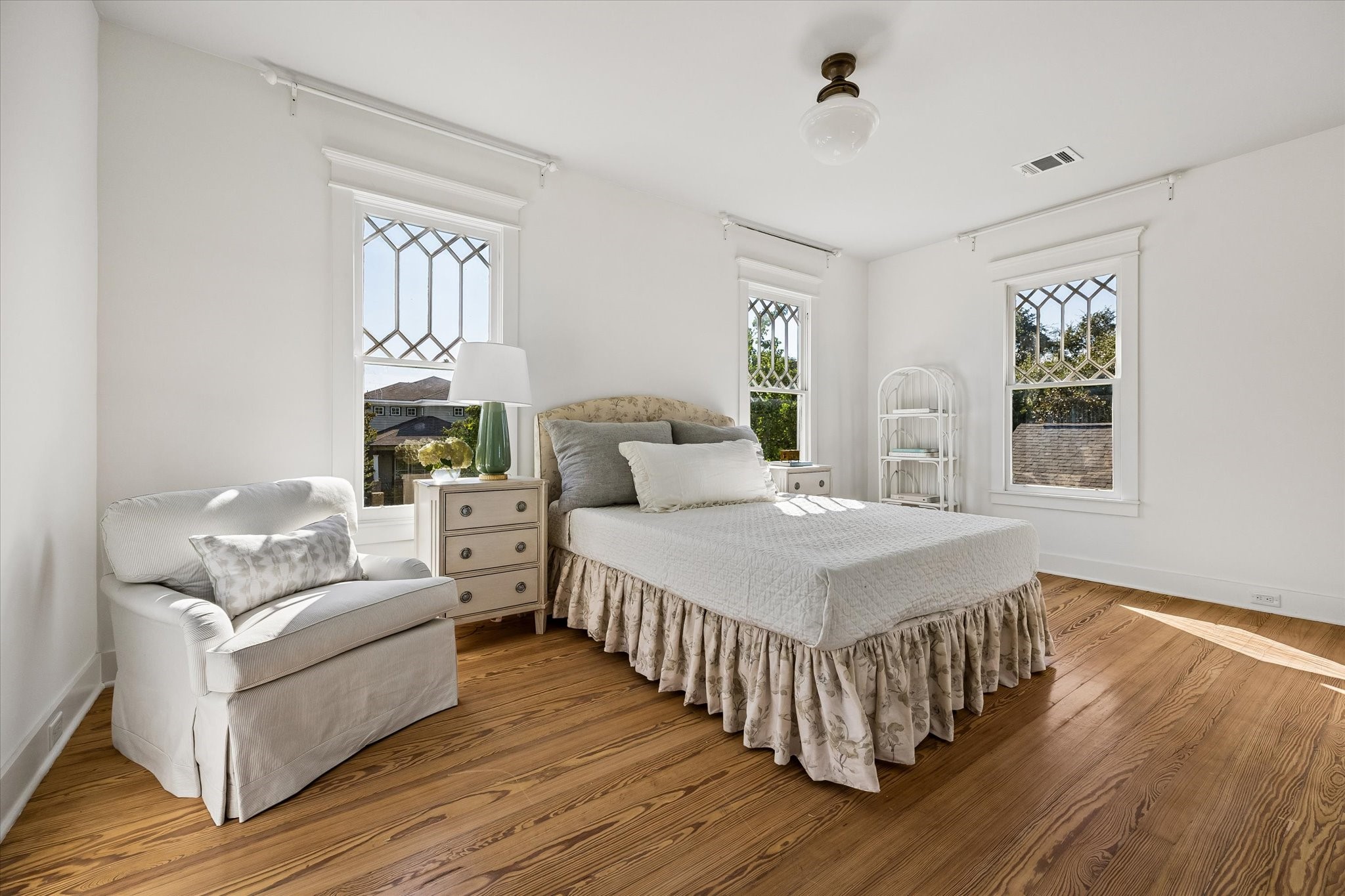 PRIMARY BEDROOM FEATURES 3 WALLS OF WINDOWS FOR PLENTY OF NATURAL LIGHT.