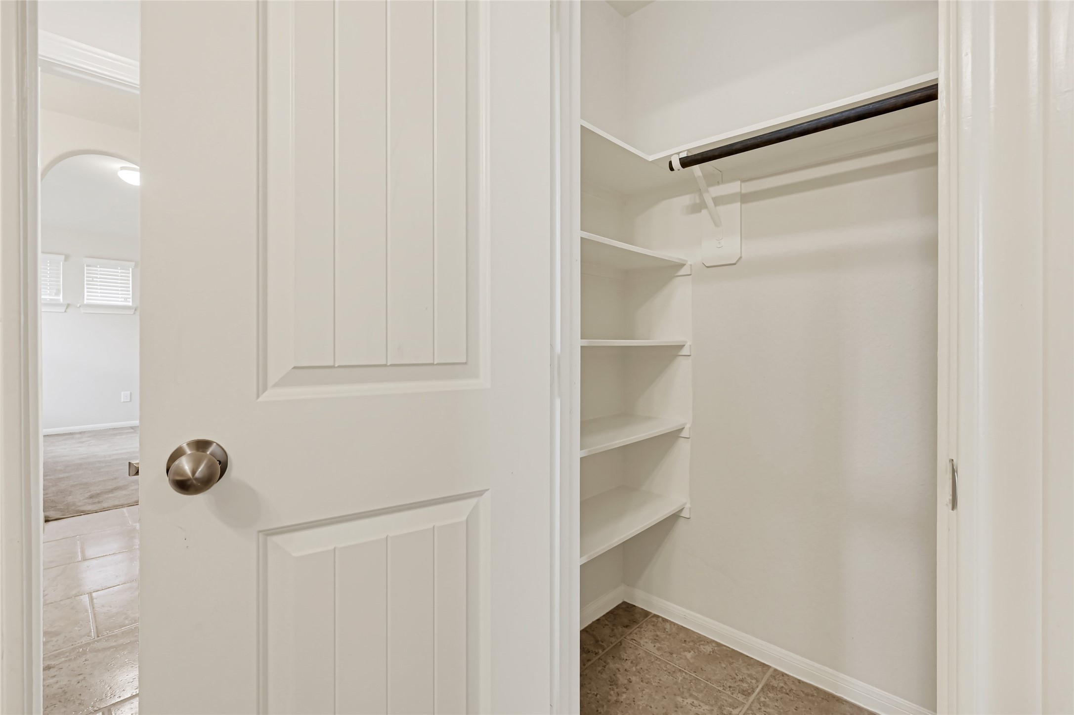 Spacious walk-in closet with built-in shelving and ample hanging space.