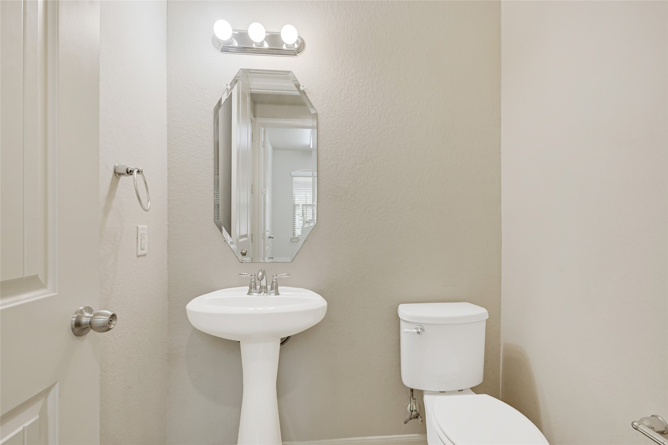 Convenient powder room with a pedestal sink, neutral finishes, and recessed lighting