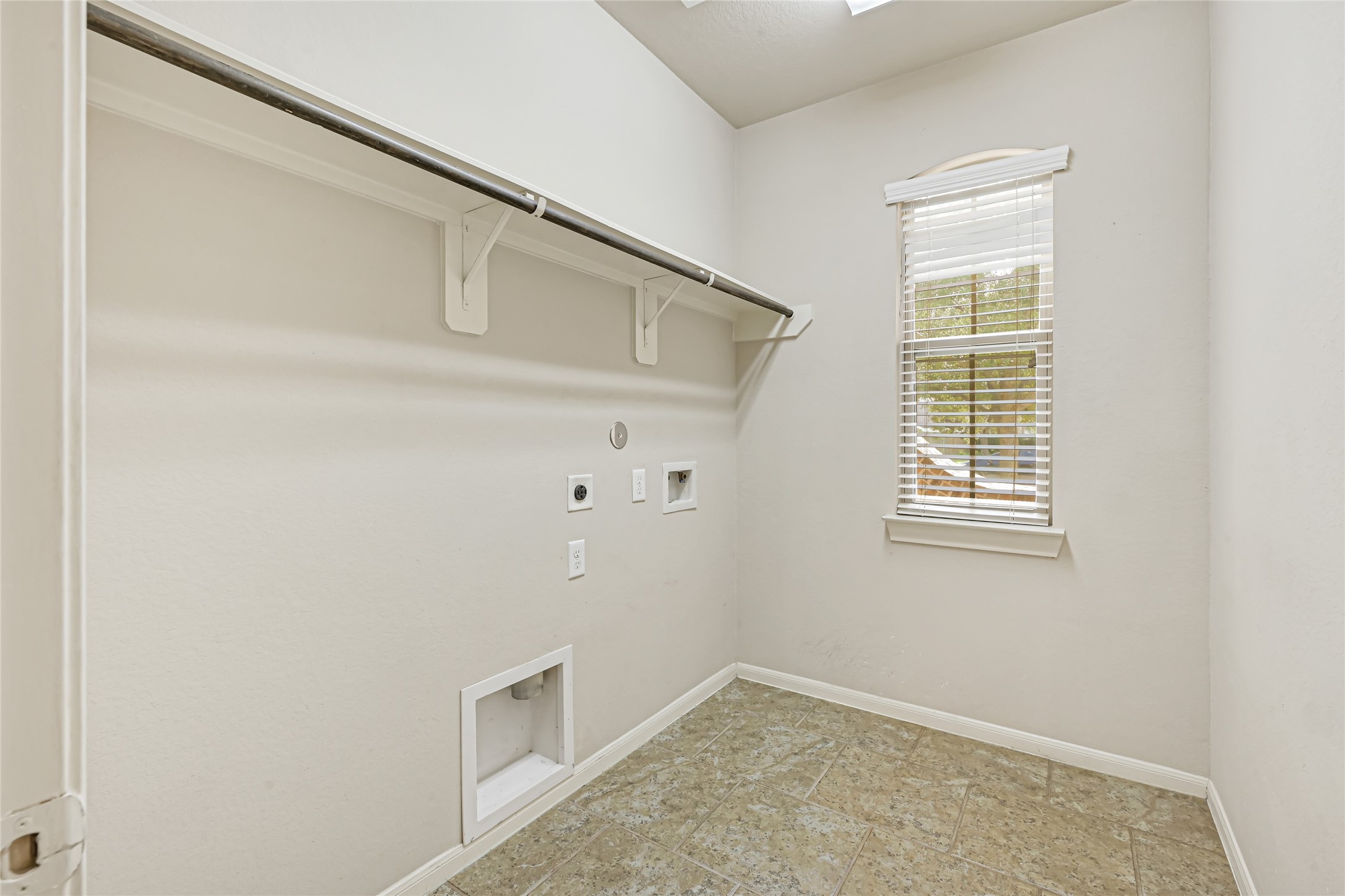 Dedicated laundry room with built-in cabinetry, hanging space, and room for full-size appliances.