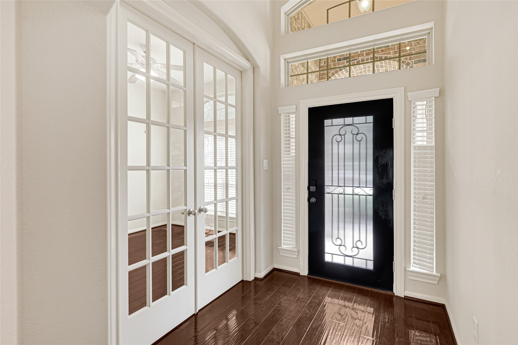 Elegant foyer with French doors, hardwood flooring, and a decorative glass front door. Elegant foyer with French doors, hardwood flooring, and a decorative glass front door.