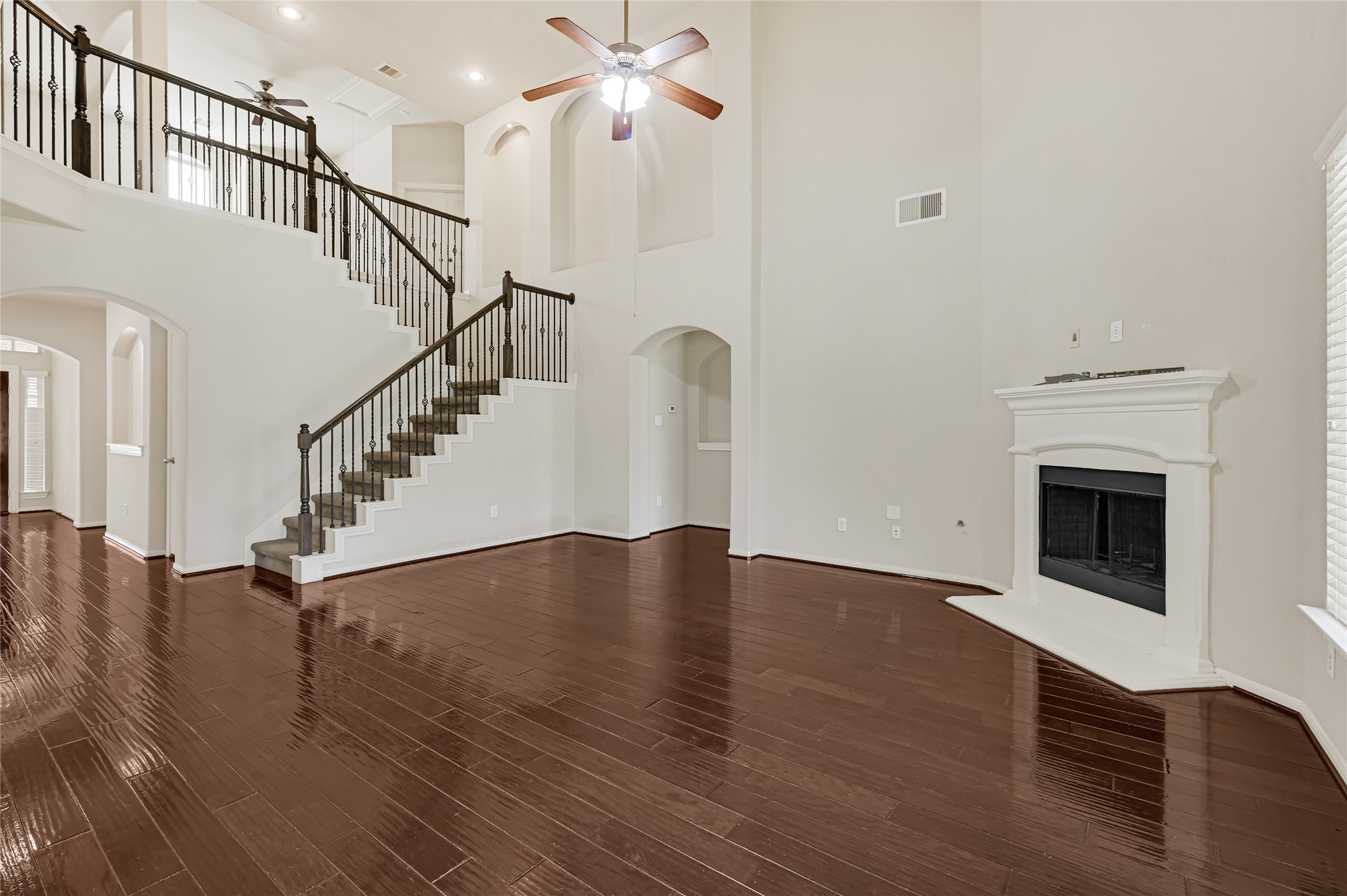 Welcoming foyer with rich hardwood flooring, an open staircase, and bright neutral finishes.