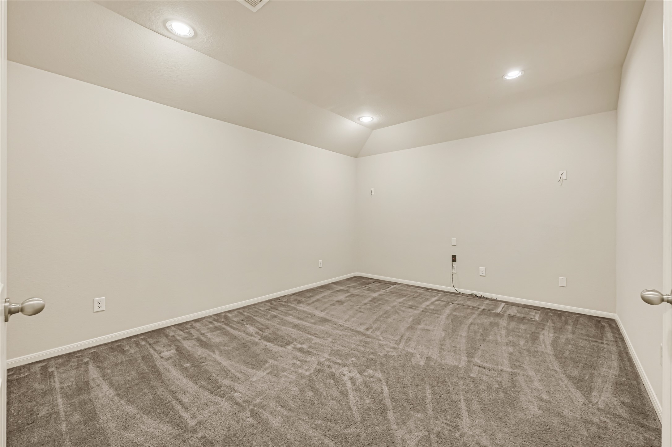 Generously sized bedroom with neutral finishes, soft carpet, and recessed lighting.