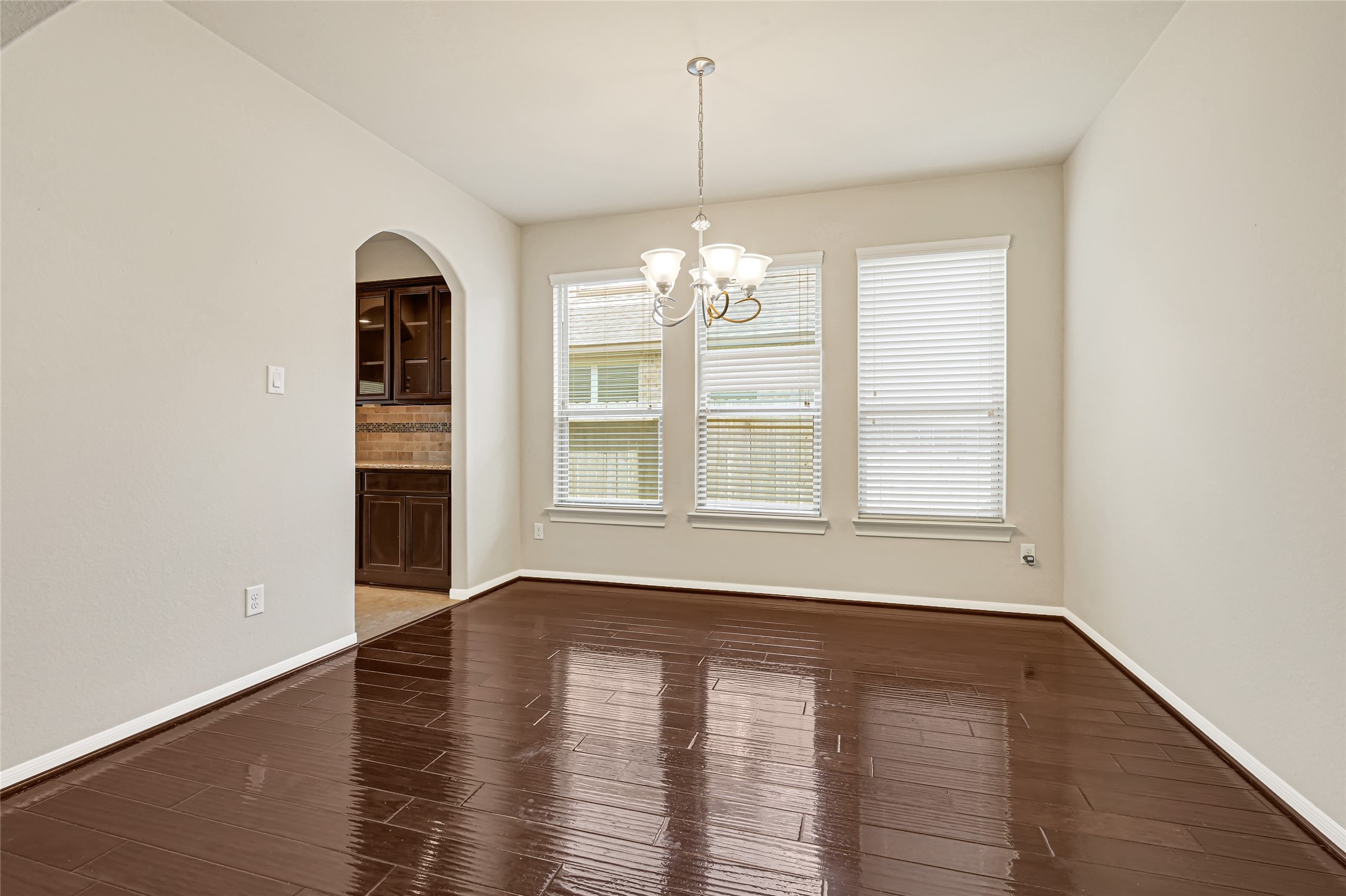 Generously sized dining room with hardwood flooring, neutral finishes, and large windows.