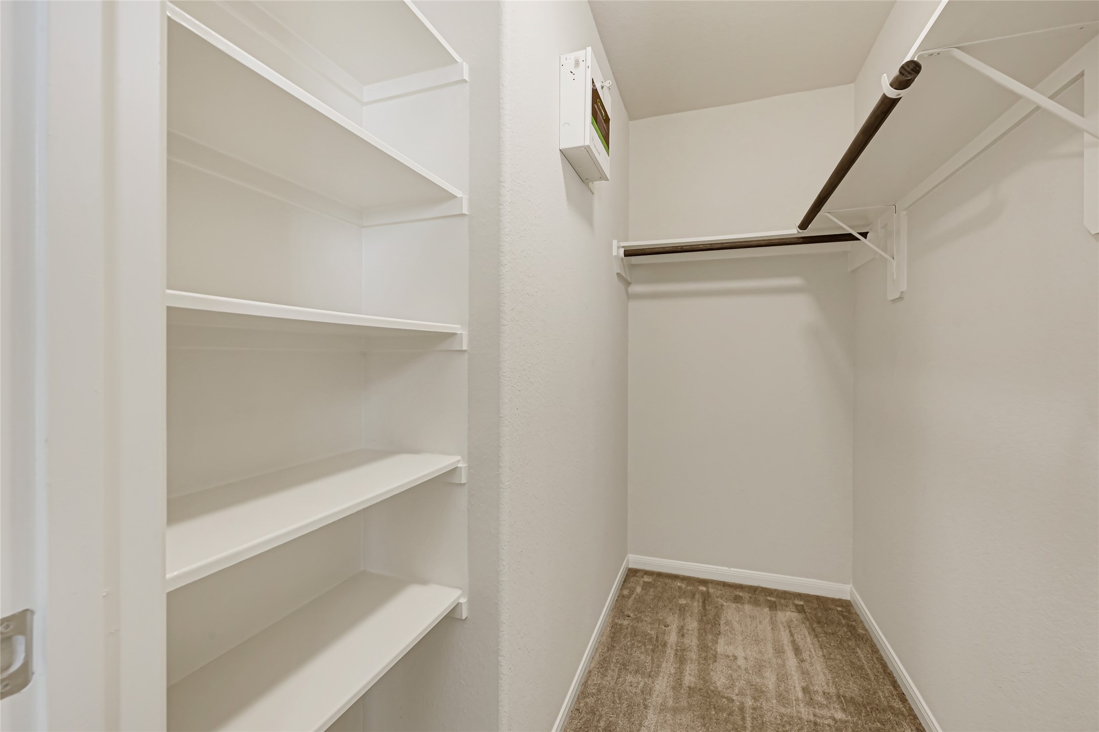 Functional walk-in closet with built-in shelving and ample storage space.