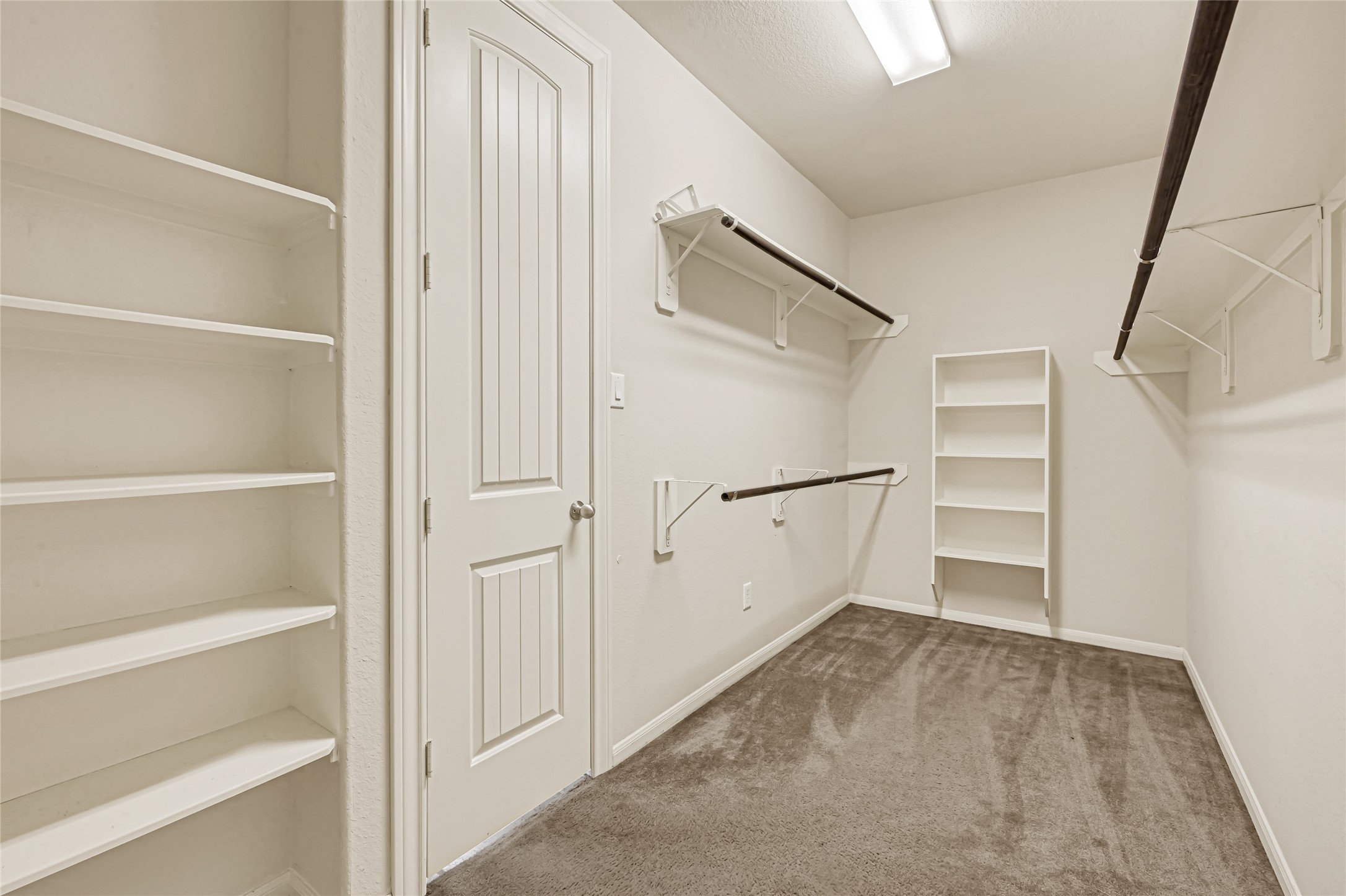 Large walk-in closet with built-in shelving, drawers, and organized storage.