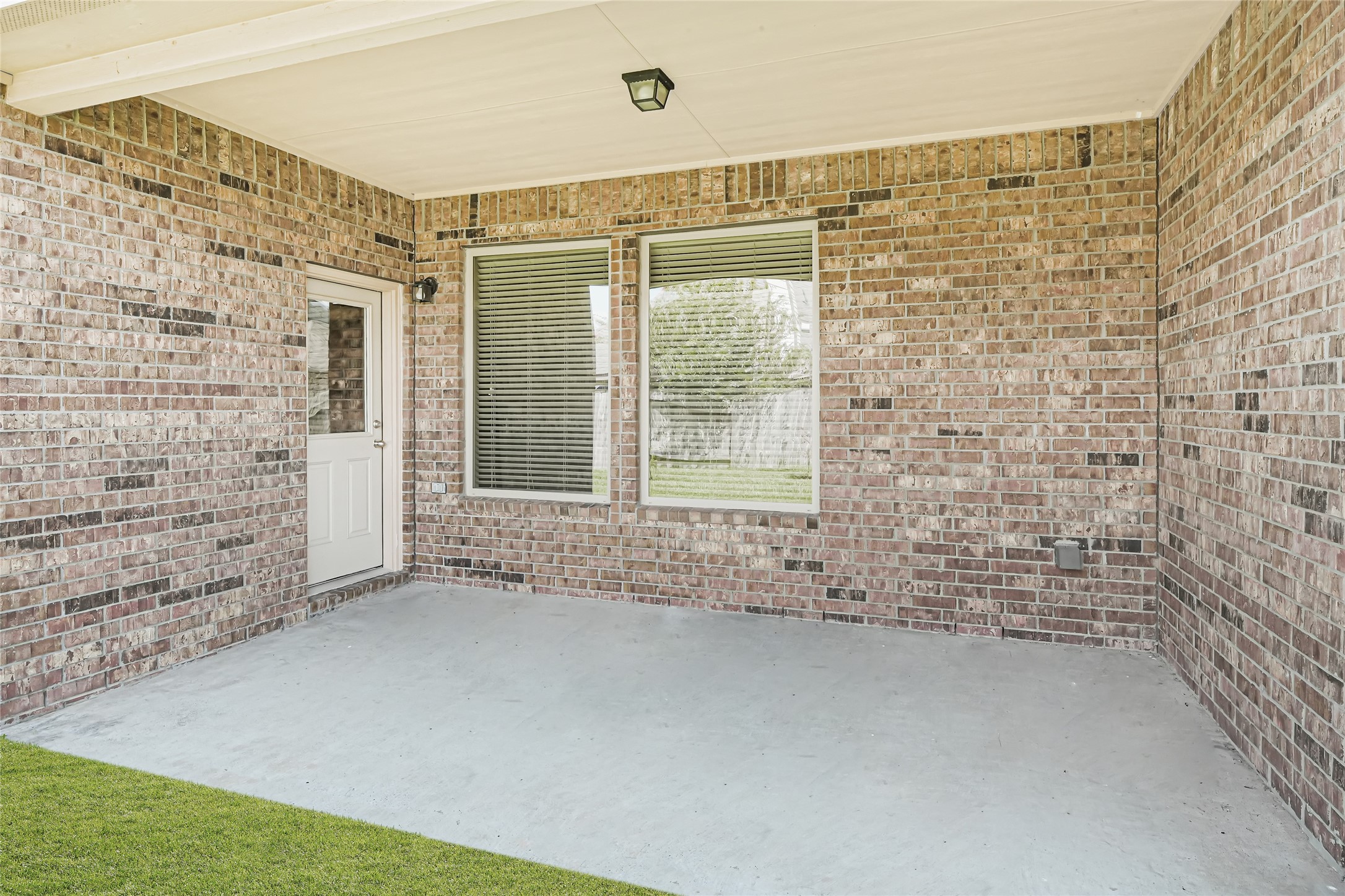 Spacious backyard with a full view of the homes brick exterior and multiple windows