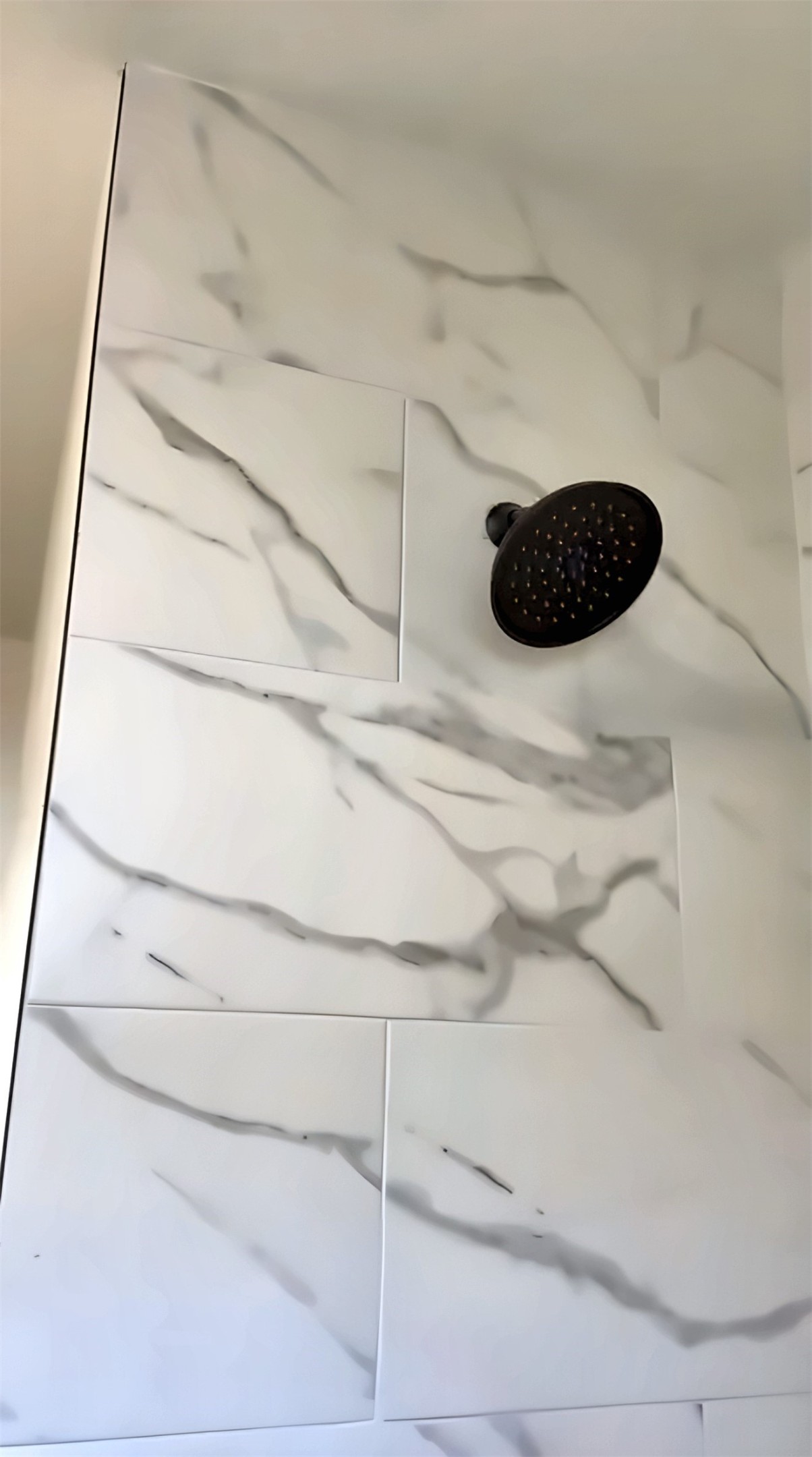 Shower with tile wall and black showerhead