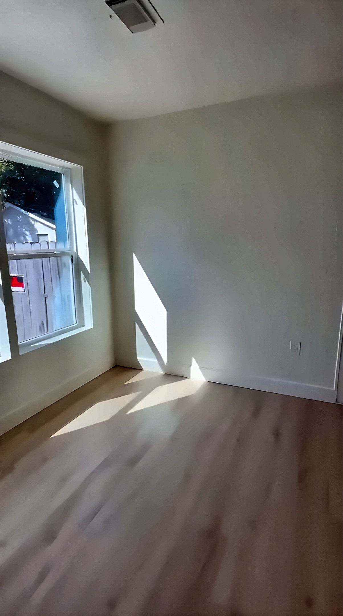 Room with large window and wood-look flooring
