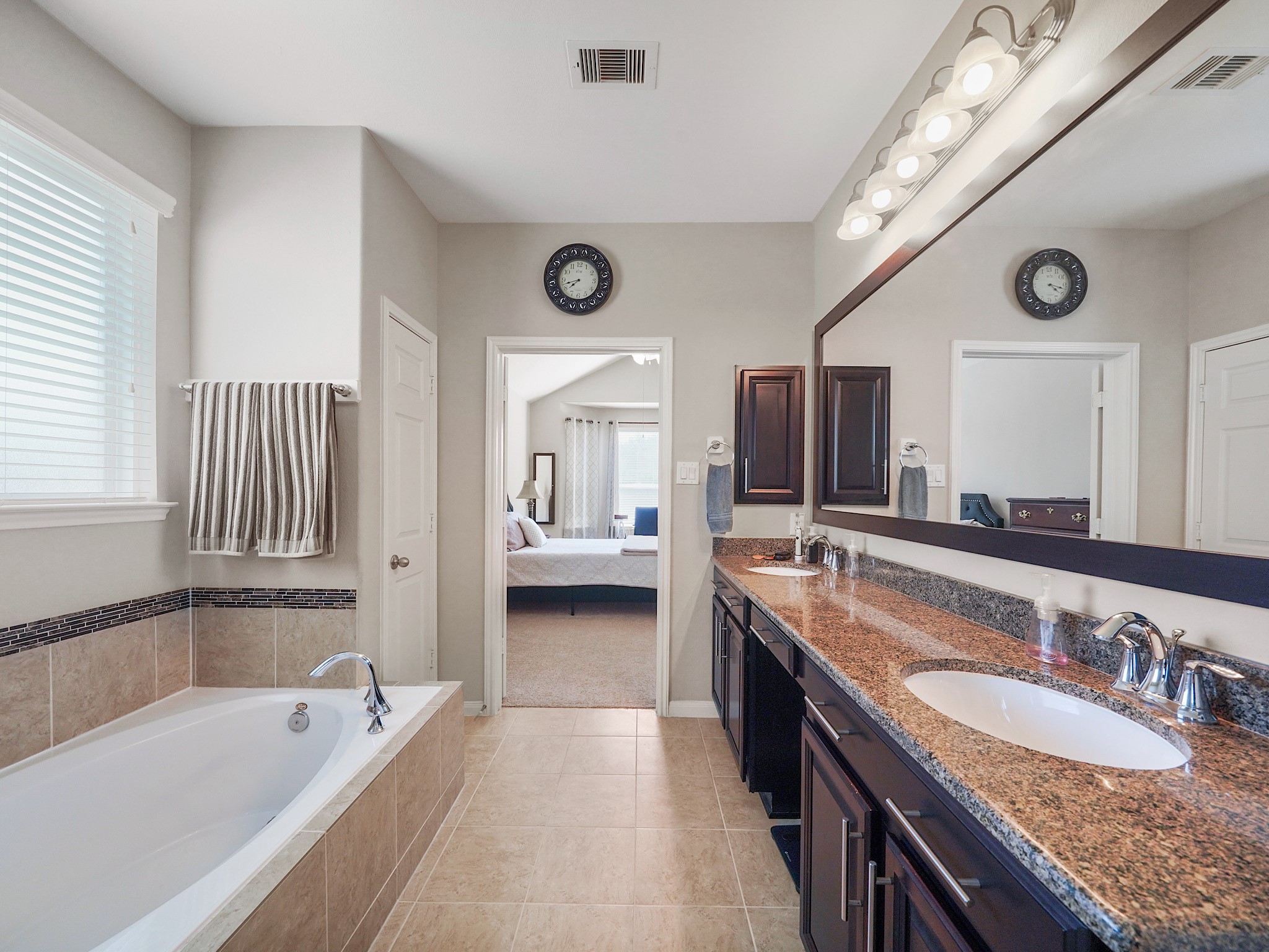 The extended vanity features dual sinks, granite countertops, and plenty of storage to keep your essentials organized and within reach. With room to get ready side by side, mornings feel a little more effortless.